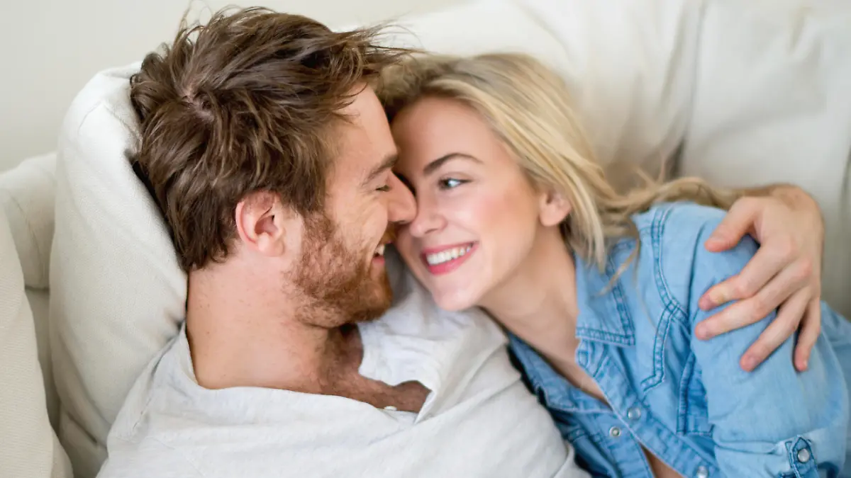 Loving couple relaxing at home lying on the sofa - relationship concepts