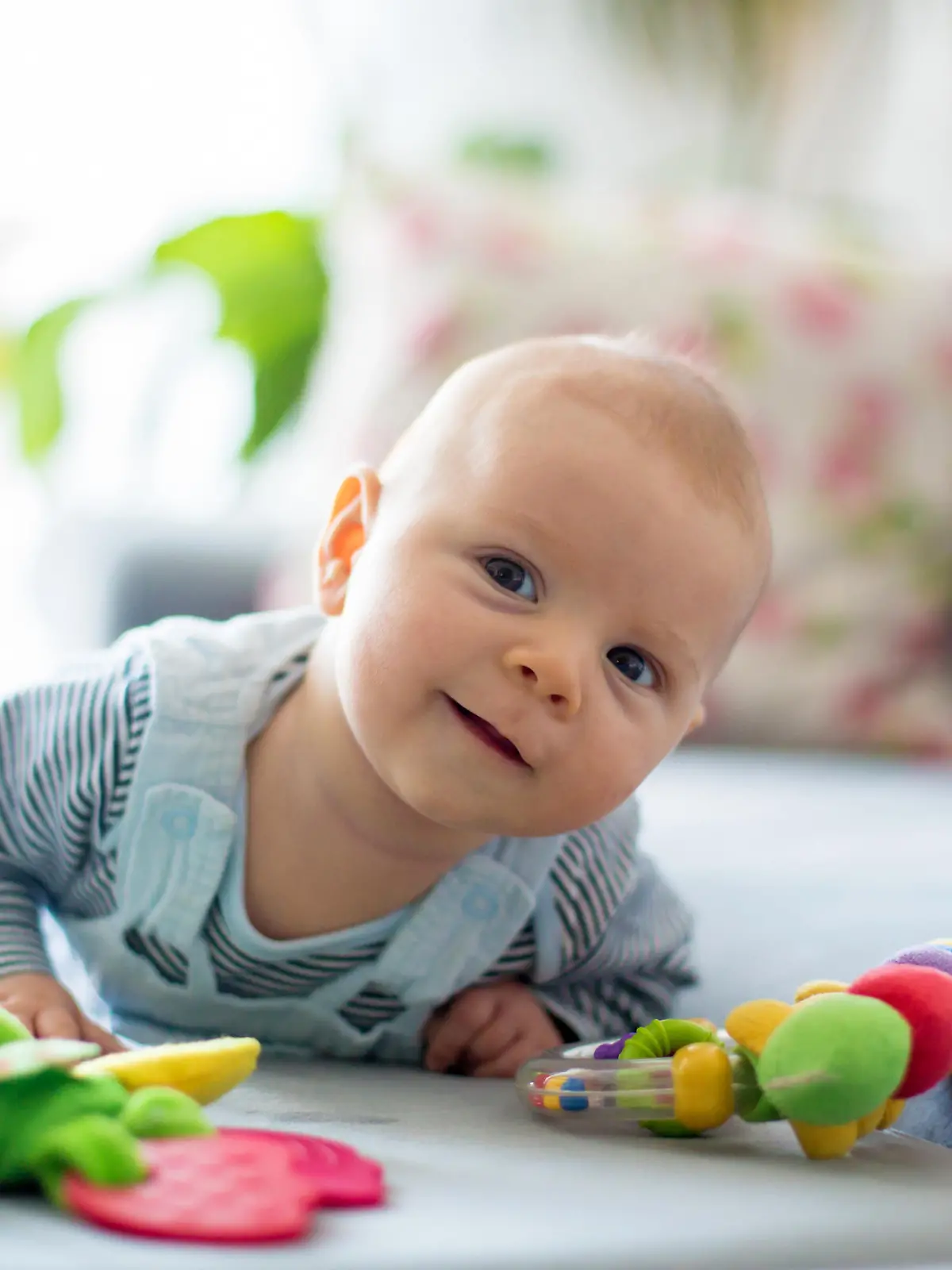 Baby robbt auf dem Bauch mit Spielzeug