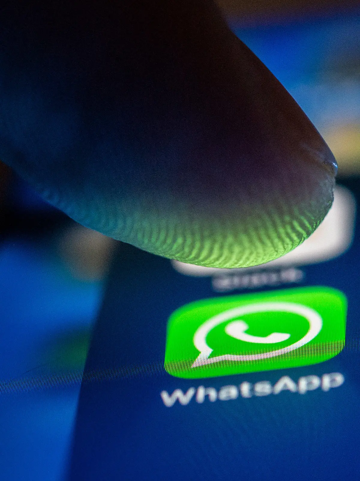 ARCHIV - 19.01.2021, Berlin: ILLUSTRATION - Ein Finger berührt das Whatsapp-Logo auf einem Smartphone. (zu dpa «Großflächige Störung bei WhatsApp») Foto: Zacharie Scheurer/dpa +++ dpa-Bildfunk +++