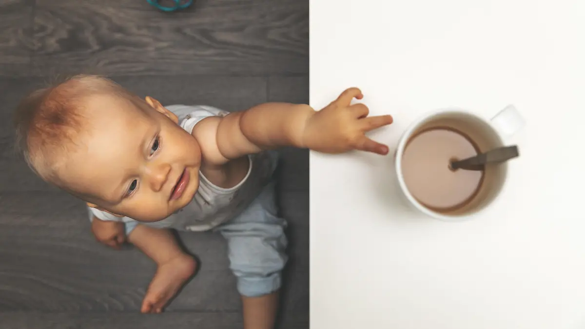 Baby greift mit Pinzettengriff nach Tasse