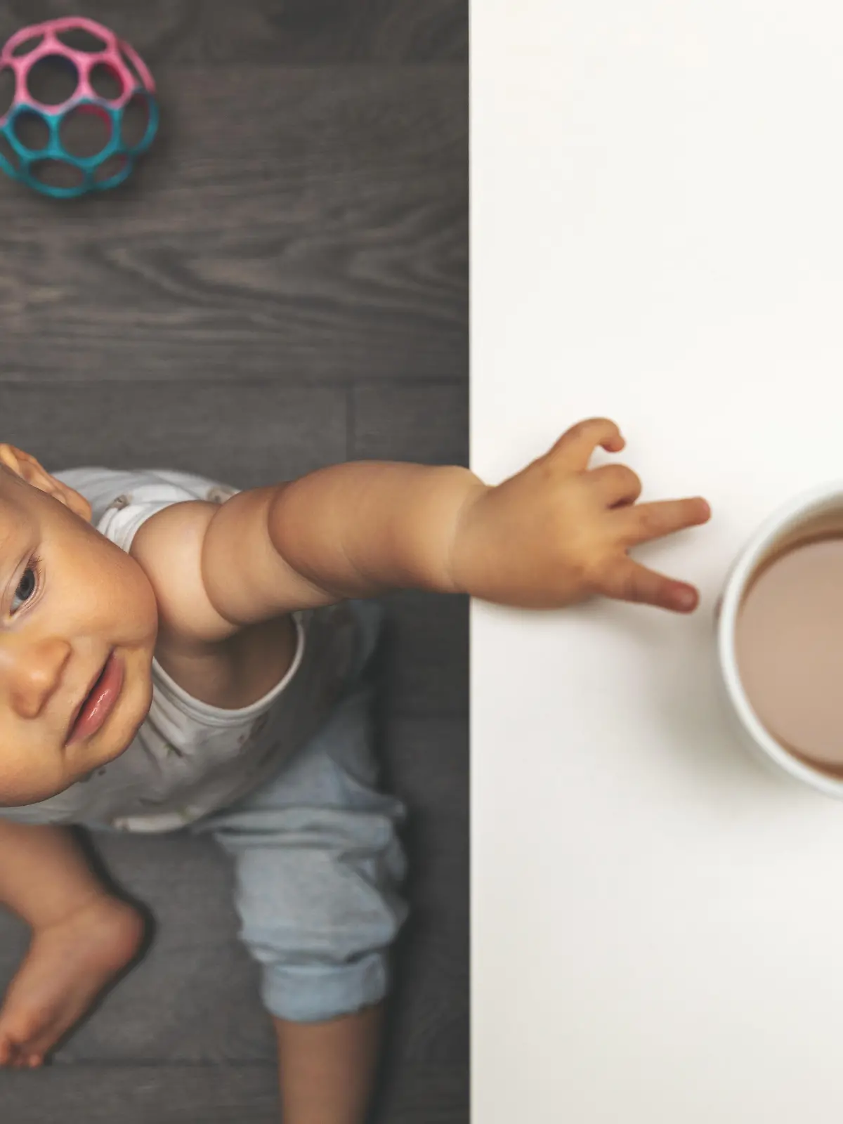 Baby greift mit Pinzettengriff nach Tasse