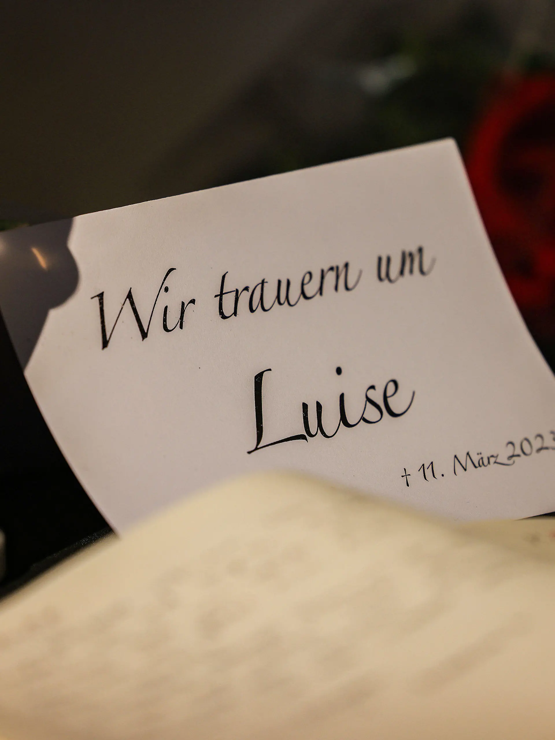 16.03.2023, Nordrhein-Westfalen, Freudenberg: Ein Kondolenzbuch liegt neben Blumen und Kerzen in einer Kirche aus. An der Schule des getöteten zwölfjährigen Mädchens Luise im südlichen Nordrhein-Westfalen sollen die Schülerinnen und Schüler nach ausführlichen Gesprächen allmählich wieder nach Stundenplan unterrichtet werden. Luise war am 11. März 2023 mit zahlreichen Messerstichen getötet worden. Foto: Oliver Berg/dpa +++ dpa-Bildfunk +++