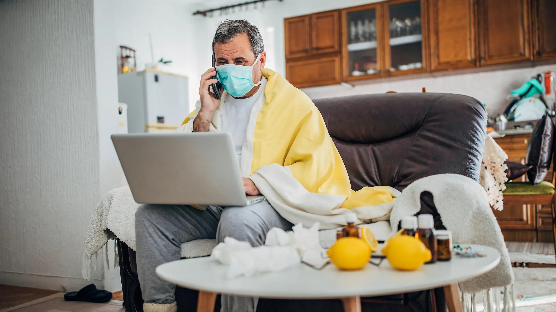 Mann mit einer Virus-Infektion sitzt zu Hause unter Quarantäne