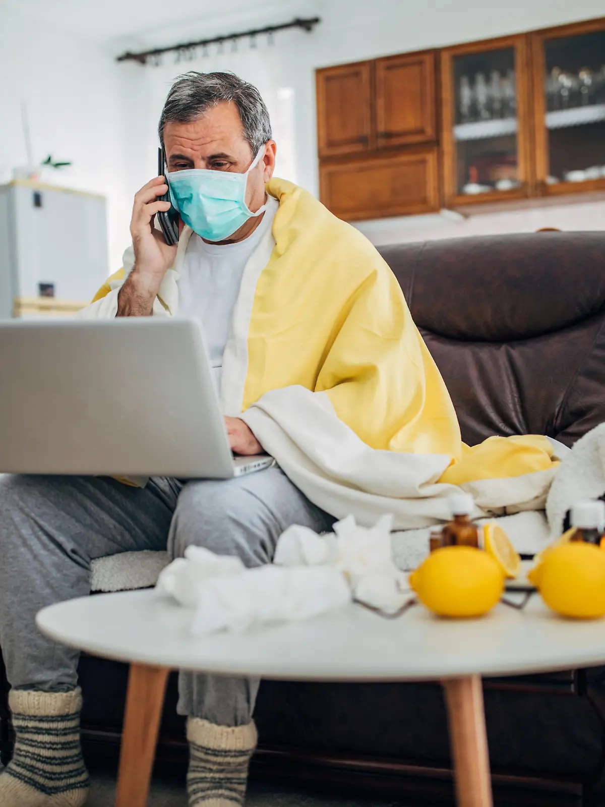Mann mit einer Virus-Infektion sitzt zu Hause unter Quarantäne