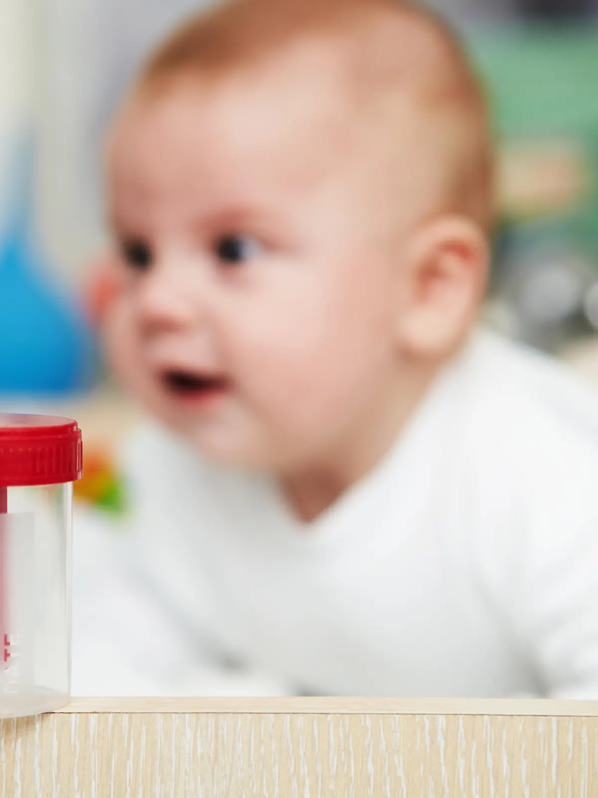 Urinprobe mit Baby im Hintergrund