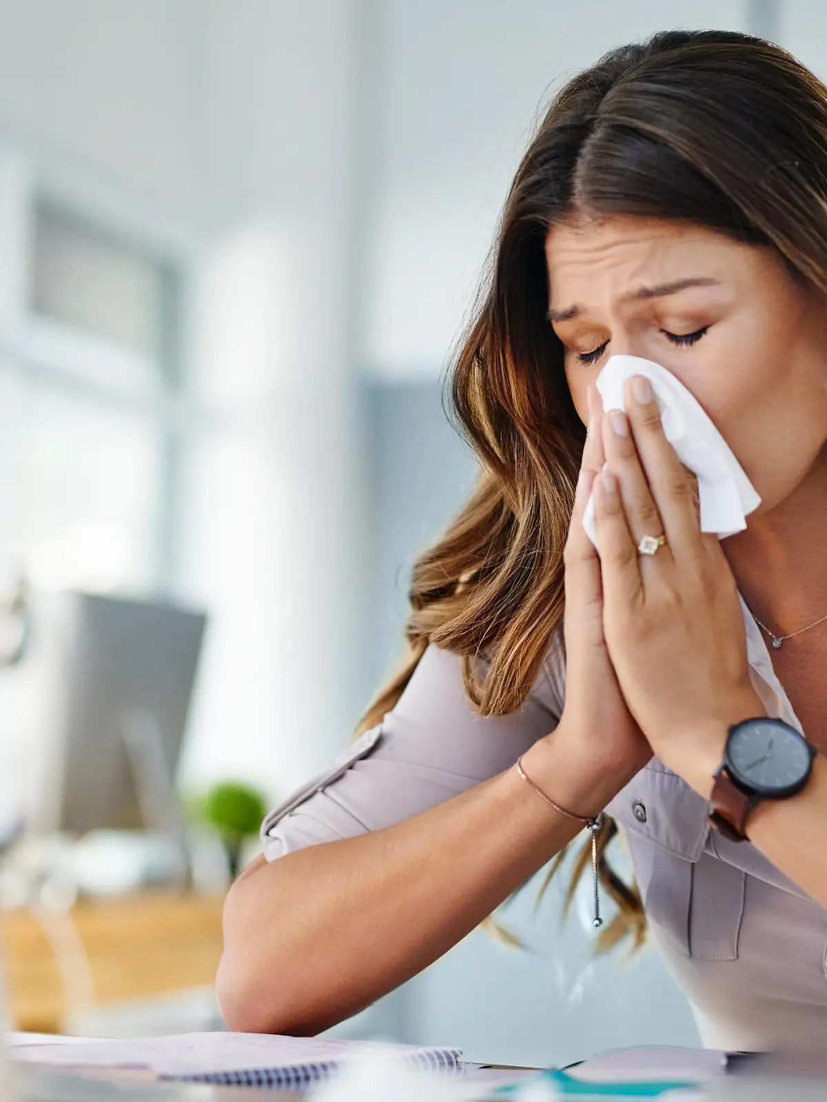 Cropped shot of a businesswoman working in her office while suffering from allergies