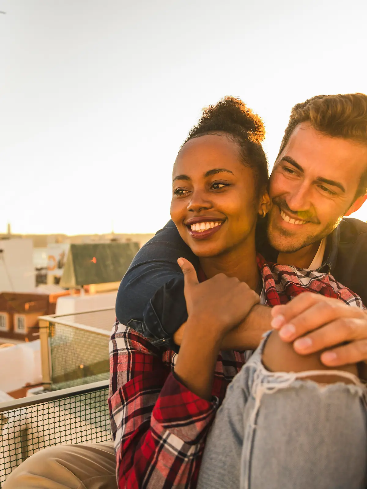 Happy affectionate young couple sitting on rooftop in the evening model released Symbolfoto property released PUBLICATIONxINxGERxSUIxAUTxHUNxONLY UUF19473