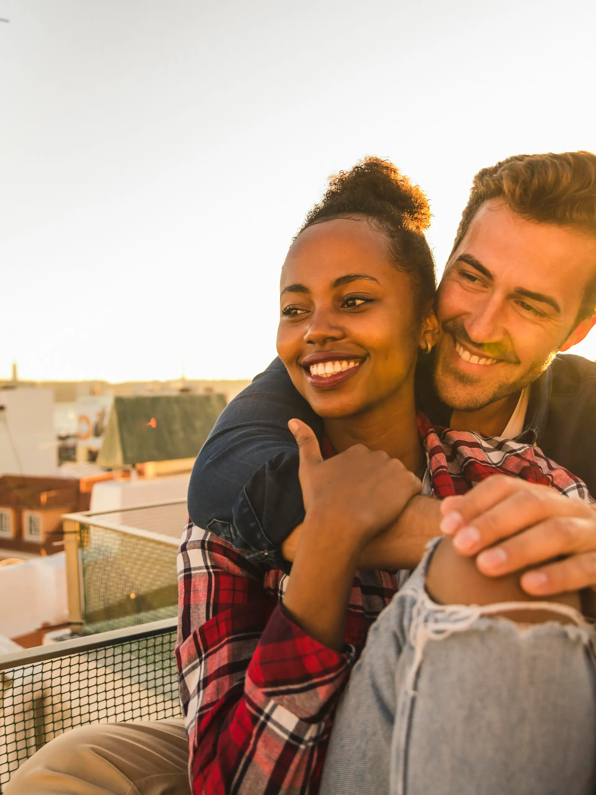 Happy affectionate young couple sitting on rooftop in the evening model released Symbolfoto property released PUBLICATIONxINxGERxSUIxAUTxHUNxONLY UUF19473