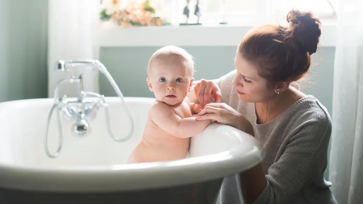 Baby wird von seiner Mutter gebadet.