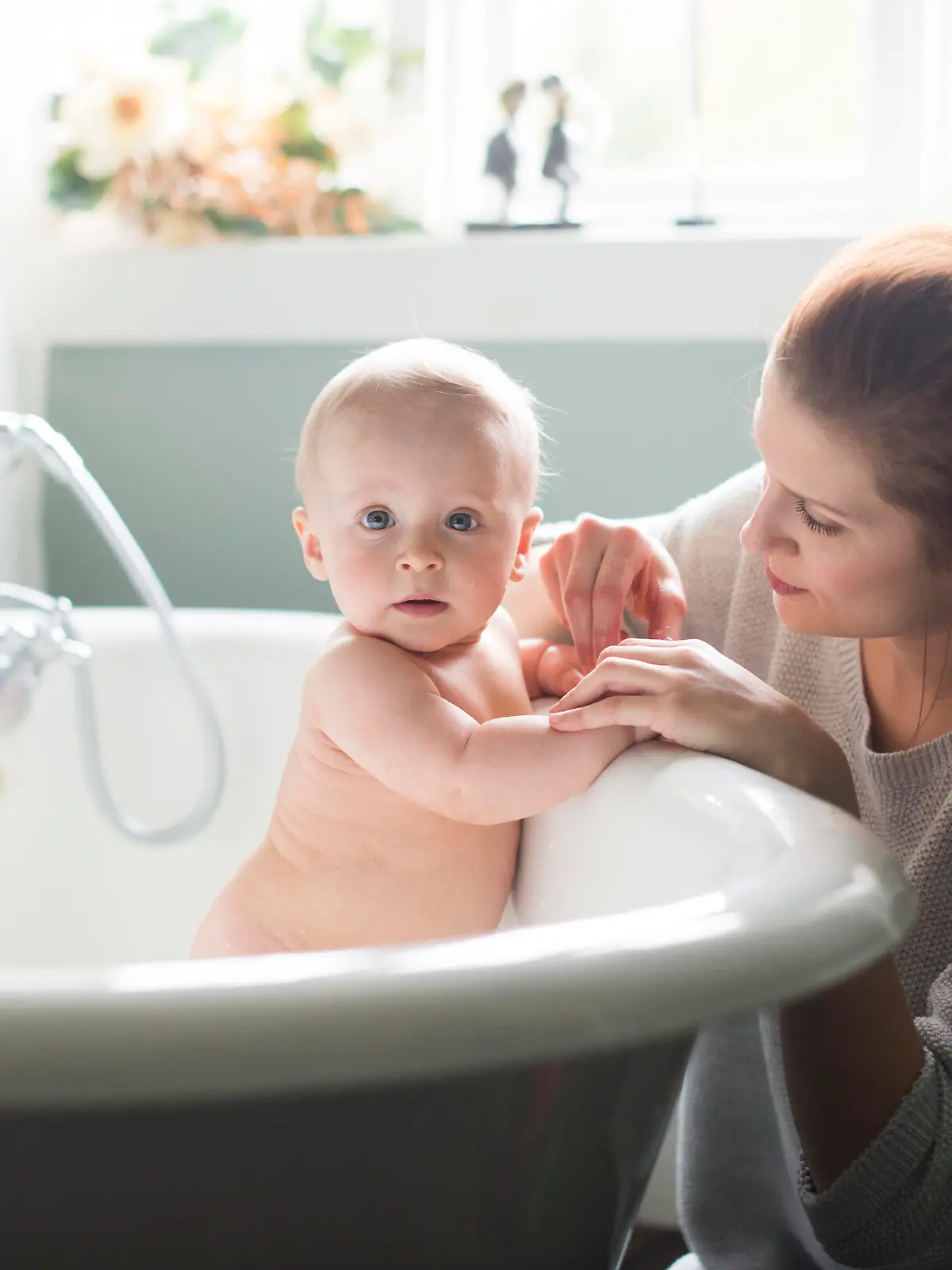 Baby wird von seiner Mutter gebadet.
