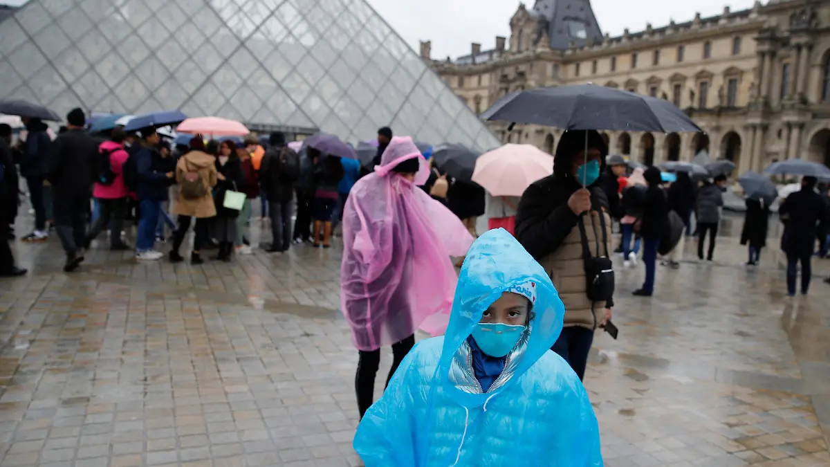 02.03.2020, Frankreich, Paris: Touristen vor dem Pariser Louvre tragen Mundschutzmasken. Der Louvre ist am Montag (02.03.20) den zweiten Tag in Folge geschlossen geblieben, weil die Mitarbeiter aus Sorge um die Coronavirus-Epidemie ihre Arbeit niedergelegt haben. Foto: Christophe Ena/AP/dpa +++ dpa-Bildfunk +++