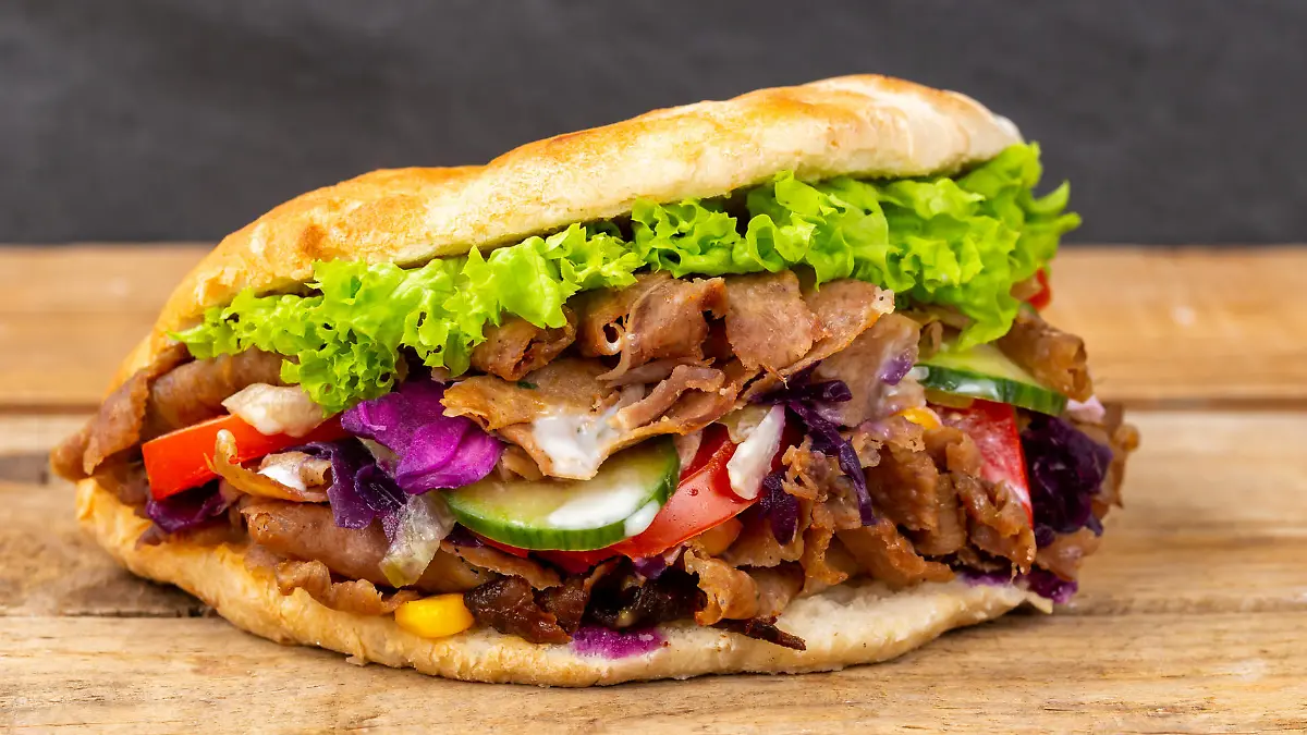 Stuttgart, Deutschland - 11. Februar 2021: Döner Kebab Doner Kebap Fastfood Essen im Fladenbrot auf Holzbrett in Stuttgart, Deutschland.