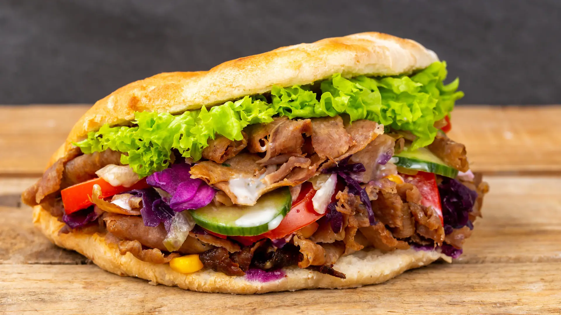 Stuttgart, Deutschland - 11. Februar 2021: Döner Kebab Doner Kebap Fastfood Essen im Fladenbrot auf Holzbrett in Stuttgart, Deutschland.