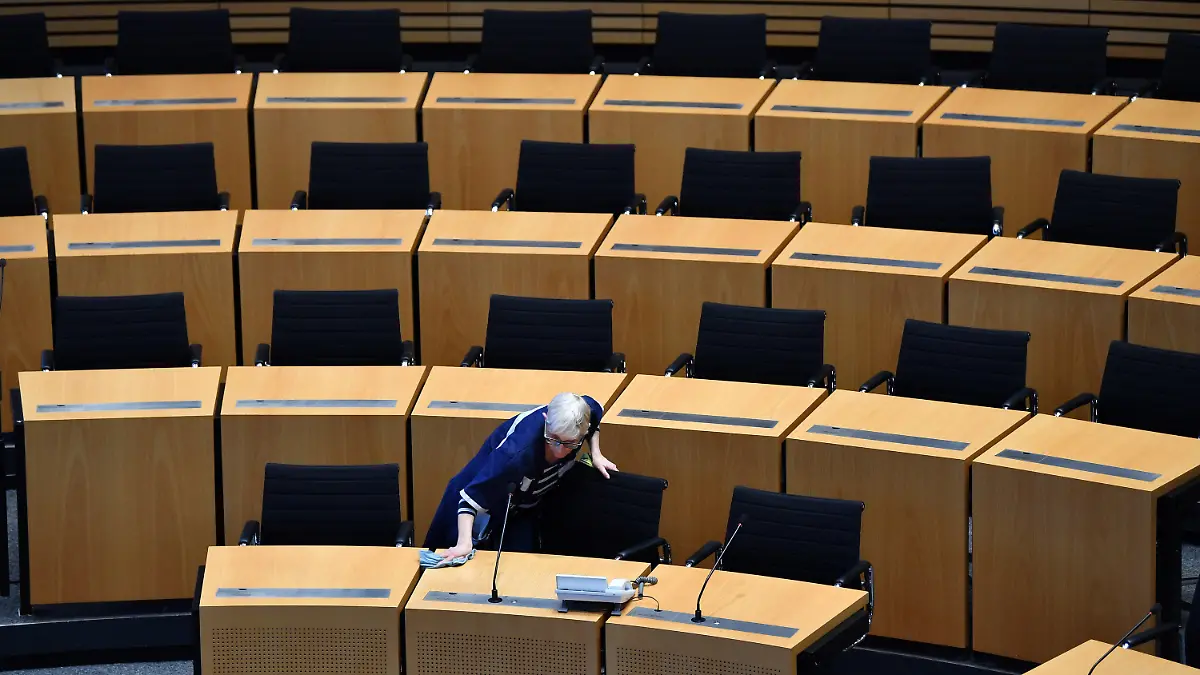 dpatopbilder - 03.03.2020, Thüringen, Erfurt: Im Plenarsaal des Thüringer Landtags werden die Plätze der Linken-Fraktion geputzt. Beim neuen Anlauf für die Ministerpräsidentenwahl in Thüringen stehen sich voraussichtlich am 4. März der Linke-Politiker Ramelow und der Thüringer AfD-Chef Höcke als Kandidaten gegenüber. Mit der neuen Wahl des Regierungschefs soll eine fast einen Monat andauernde Krise in Thüringen beendet werden. Foto: Martin Schutt/dpa-Zentralbild/dpa +++ dpa-Bildfunk +++