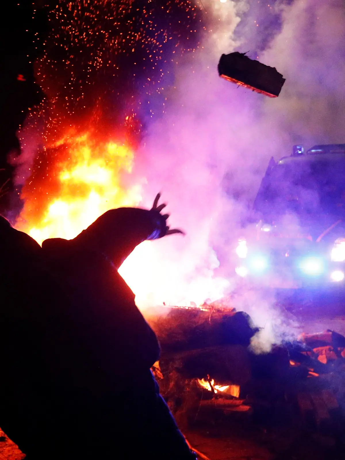 A demonstrator throws a stone towards a police van during a protest against the arrival of a plane carrying evacuees from coronavirus-hit China's Hubei province in the village of Novi Sanzhary in Poltava region, Ukraine February 20, 2020. Local residents blocked the road leading to a sanatorium where the evacuees are due to be held in quarantine for at least two weeks. REUTERS/Valentyn Ogirenko