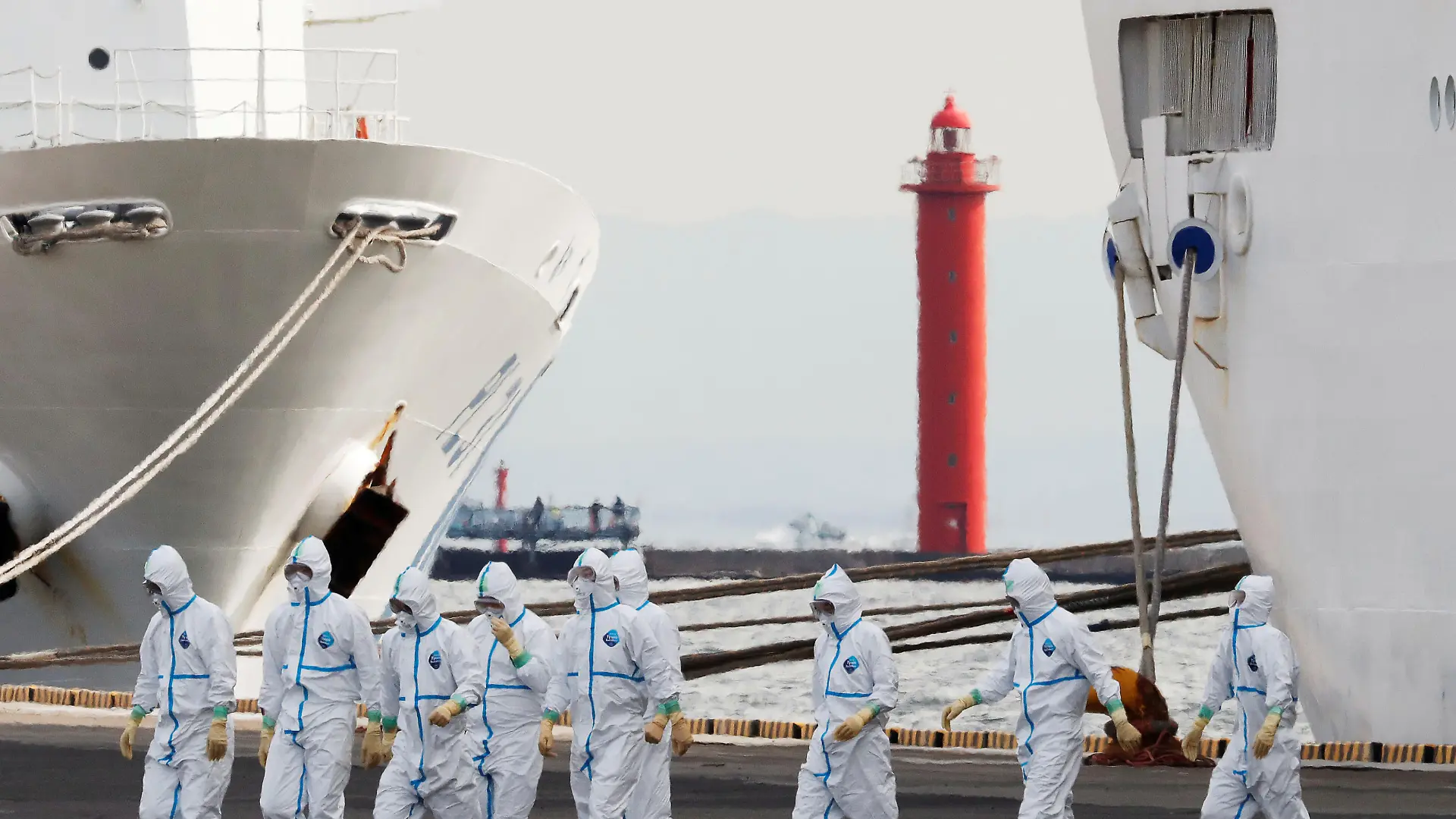 Men wearing protective gear are seen near the cruise ship Diamond Princess, where 10 more people were tested positive for coronavirus on Thursday, at Daikoku Pier Cruise Terminal in Yokohama, south of Tokyo, Japan February 7, 2020. REUTERS/Kim Kyung-Hoon