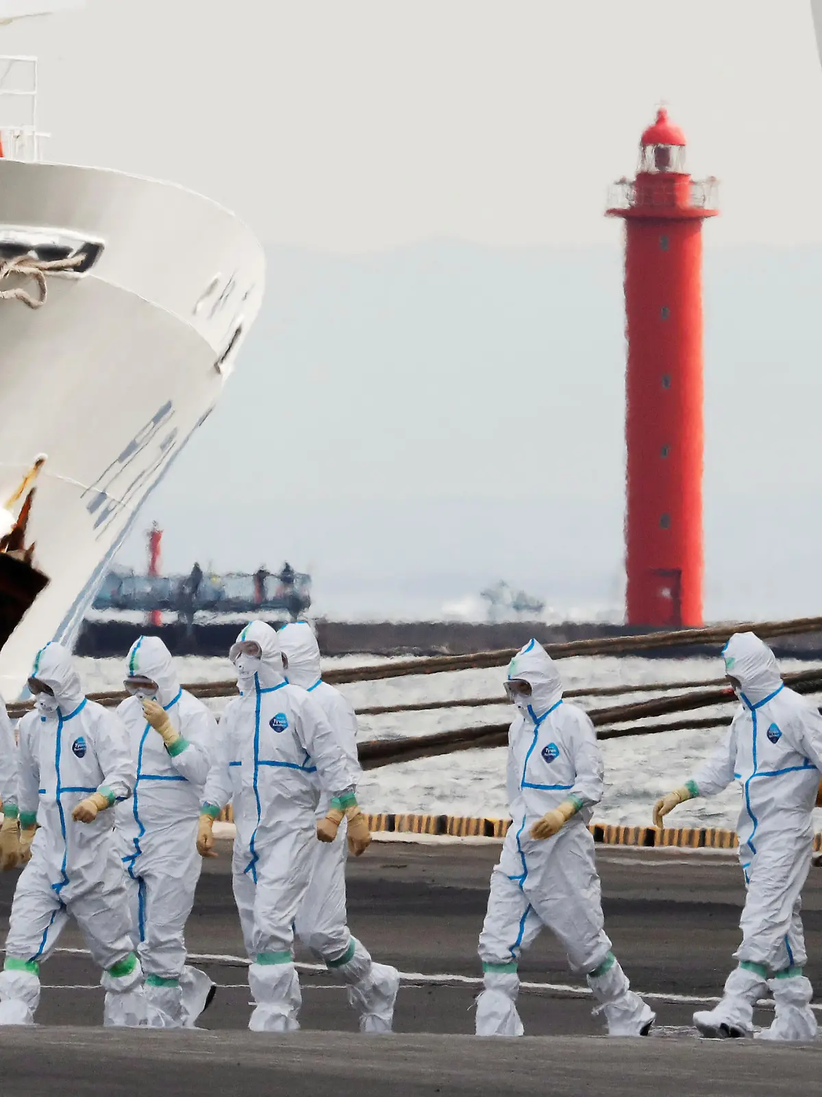 Men wearing protective gear are seen near the cruise ship Diamond Princess, where 10 more people were tested positive for coronavirus on Thursday, at Daikoku Pier Cruise Terminal in Yokohama, south of Tokyo, Japan February 7, 2020. REUTERS/Kim Kyung-Hoon