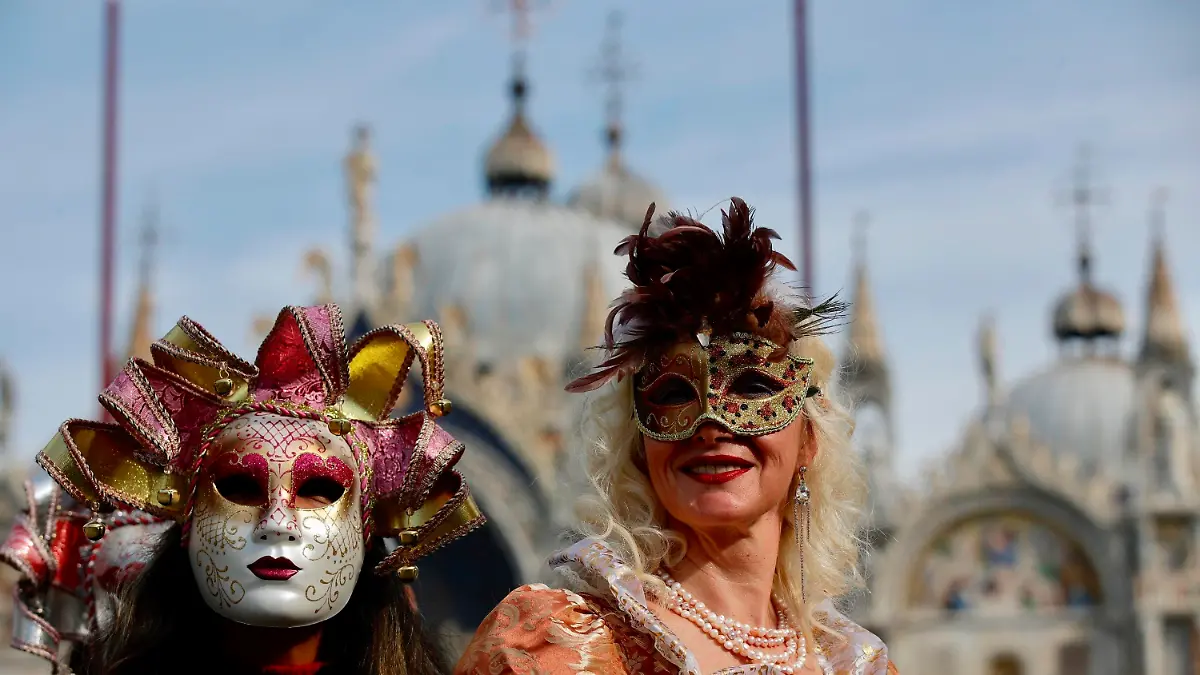 16.02.2020, Italien, Venedig: Verkleidete Karnevalsteilnehmer tragen bunte Masken auf dem Markusplatz. Der venezianische Karneval ist ein wochenlanges Volksfest, das in die römisch-katholische Fastenzeit mündet. Sein offizieller Beginn ist zwei Wochen vor Aschermittwoch und endet am Karnevalsdienstag. Foto: Luca Bruno/AP/dpa +++ dpa-Bildfunk +++