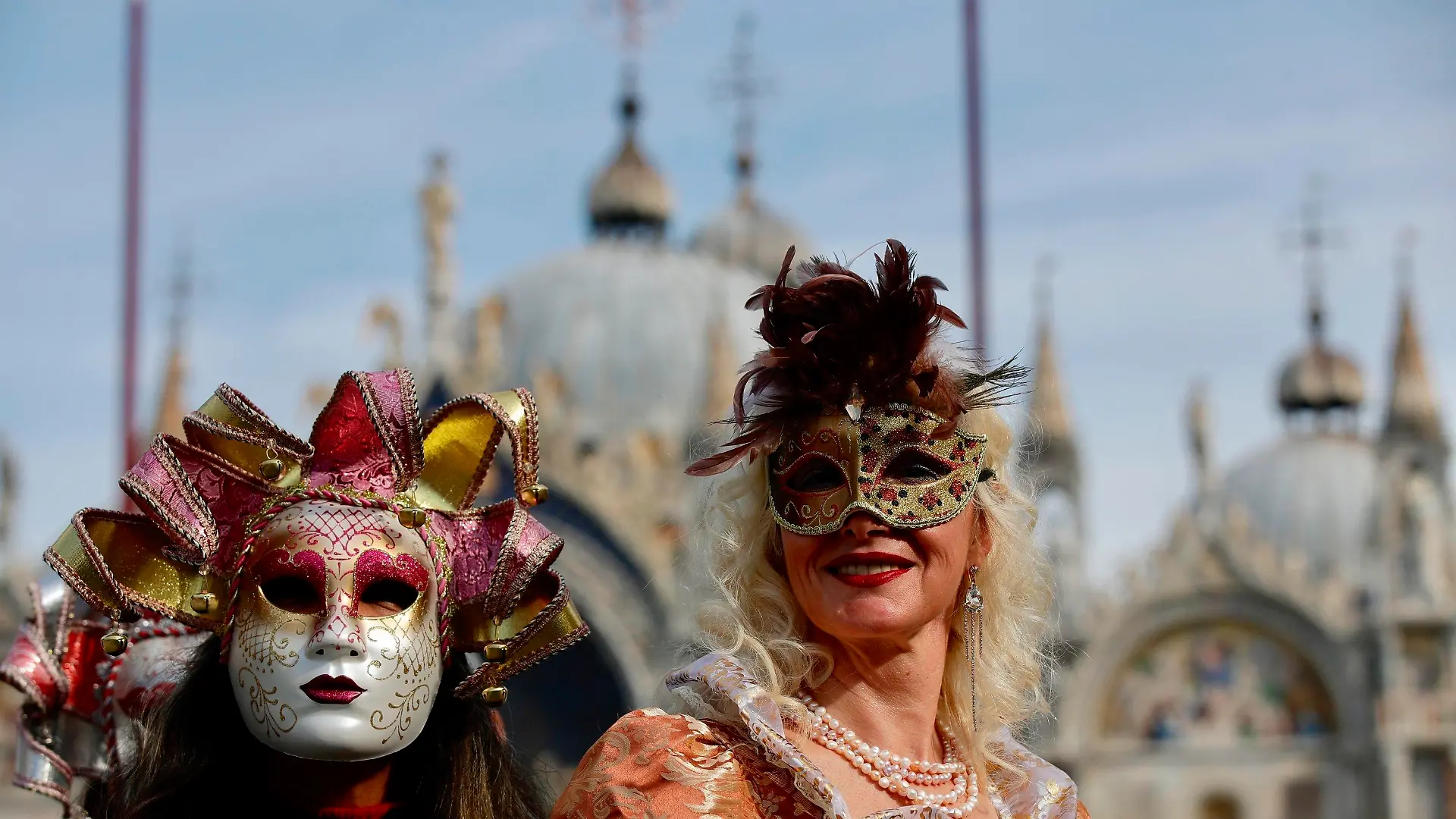 16.02.2020, Italien, Venedig: Verkleidete Karnevalsteilnehmer tragen bunte Masken auf dem Markusplatz. Der venezianische Karneval ist ein wochenlanges Volksfest, das in die römisch-katholische Fastenzeit mündet. Sein offizieller Beginn ist zwei Wochen vor Aschermittwoch und endet am Karnevalsdienstag. Foto: Luca Bruno/AP/dpa +++ dpa-Bildfunk +++