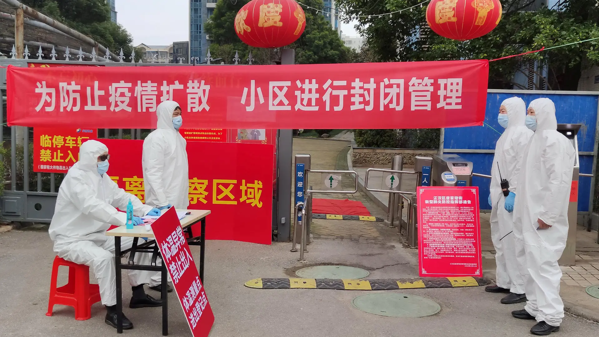 FILE PHOTO: Workers in protective suits are seen at a checkpoint for registration and body temperature measurement, at an entrance to a residential compound in Wuhan, the epicentre of the novel coronavirus outbreak, in Hubei province, China February 13, 2020. China Daily via REUTERS/File Photo ATTENTION EDITORS - THIS IMAGE WAS PROVIDED BY A THIRD PARTY. CHINA OUT.