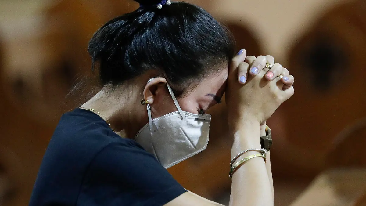 30.01.2020, Philippinen, Manila: Eine Frau mit Atemschutzmaske betet während einer Messe. Die Zahl der Infektionen und Todesopfer durch die Lungenkrankheit aus China ist weltweit erneut gestiegen. Foto: Aaron Favila/AP/dpa +++ dpa-Bildfunk +++
