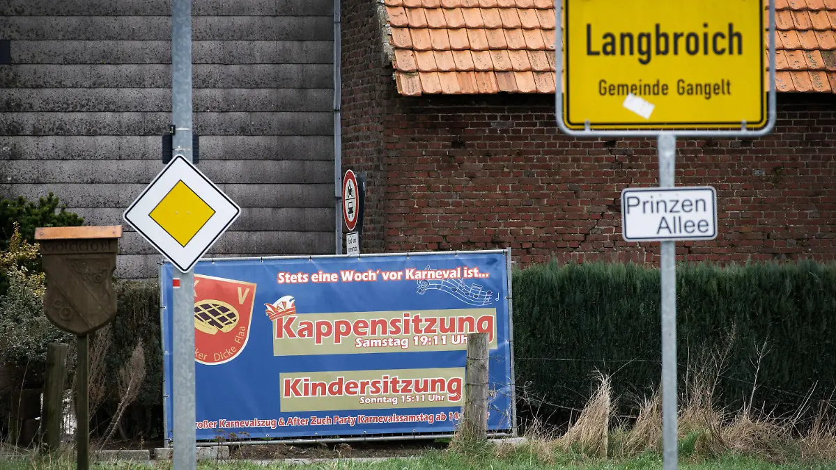 27.02.2020, Nordrhein-Westfalen, Gangelt: Ein Plakat lädt am Eingang im Ortsteil Langbroich zur Karnevalsveranstaltung "Kappensitzung". In Gangelt im Kreis Heinsberg sind die rund 300 Besucher der Karnevalsveranstaltung aufgerufen, sich bei den Behörden zu melden. Alle Besucher und ihre Familien müssten für 14 Tage in häusliche Quarantäne gehen, teilte das NRW-Gesundheitsministerium in der Nacht zum Donnerstag mit. Foto: Henning Kaiser/dpa +++ dpa-Bildfunk +++