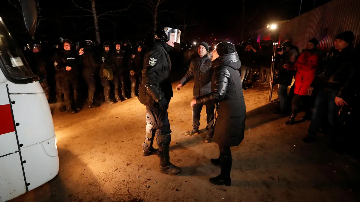 Demonstrators argue with a law enforcement during a protest against the arrival of buses with evacuees from coronavirus-hit China's Hubei province in the village of Novi Sanzhary in Poltava region, Ukraine February 20, 2020. REUTERS/Valentyn Ogirenko