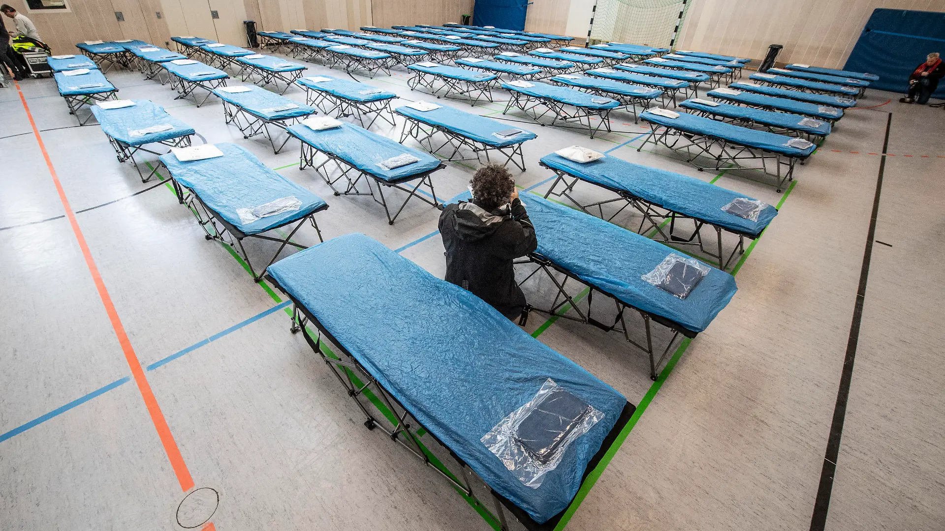 31.01.2020, Hessen, Frankfurt/Main: Dutzende Feldbetten stehen in einer Turnhalle auf dem Gelände des Flughafens in Frankfurt für die Ankunft von rund 90 Menschen aus dem vom Corona-Virus besonders betroffenen chinesischen Gebiet um Wuhan bereit. Die Menschen - darunter auch Kinder - werden am Samstag in Frankfurt erwartet und sollen nach einer ersten Untersuchung ins rheinland-pfälzische Germersheim gebracht werden, wo sie weitere zwei Wochen in Quarantäne bleiben sollen. Foto: Boris Roessler/dpa +++ dpa-Bildfunk +++