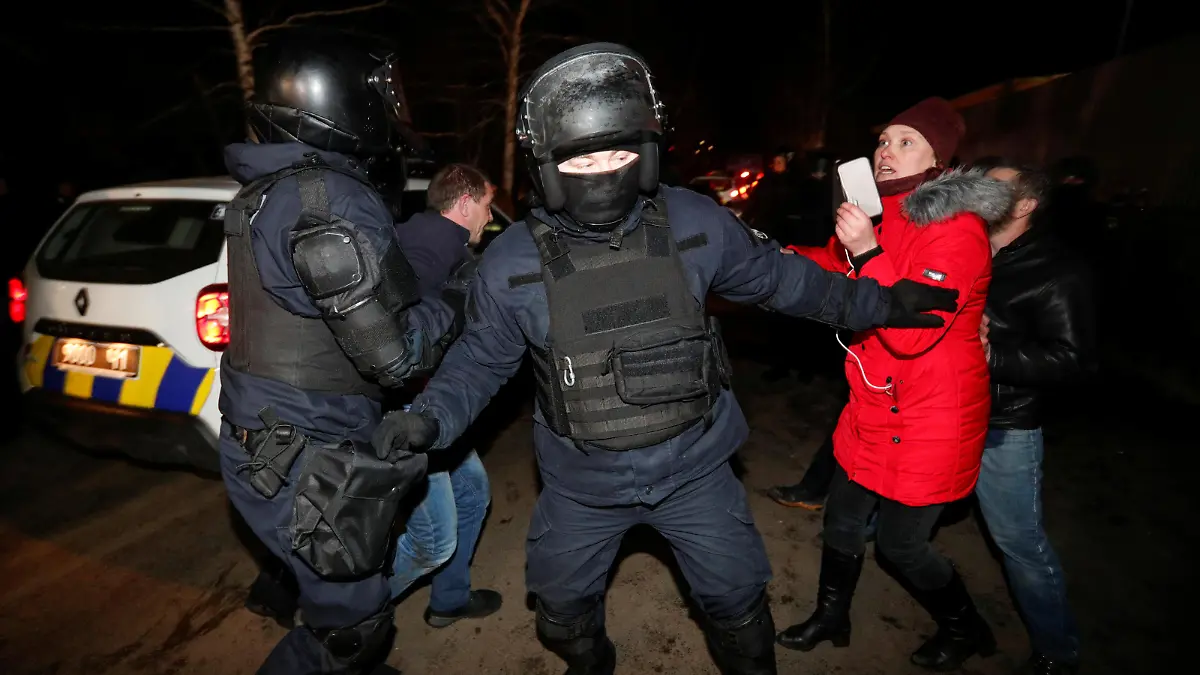 Ukrainian law enforcement officers clear the way as demonstrators attempt to block a road during a protest against the arrival of a plane carrying evacuees from coronavirus-hit China's Hubei province in the village of Novi Sanzhary in Poltava region, Ukraine February 20, 2020. Local residents blocked the road leading to a sanatorium where the evacuees are due to be held in quarantine for at least two weeks. REUTERS/Valentyn Ogirenko