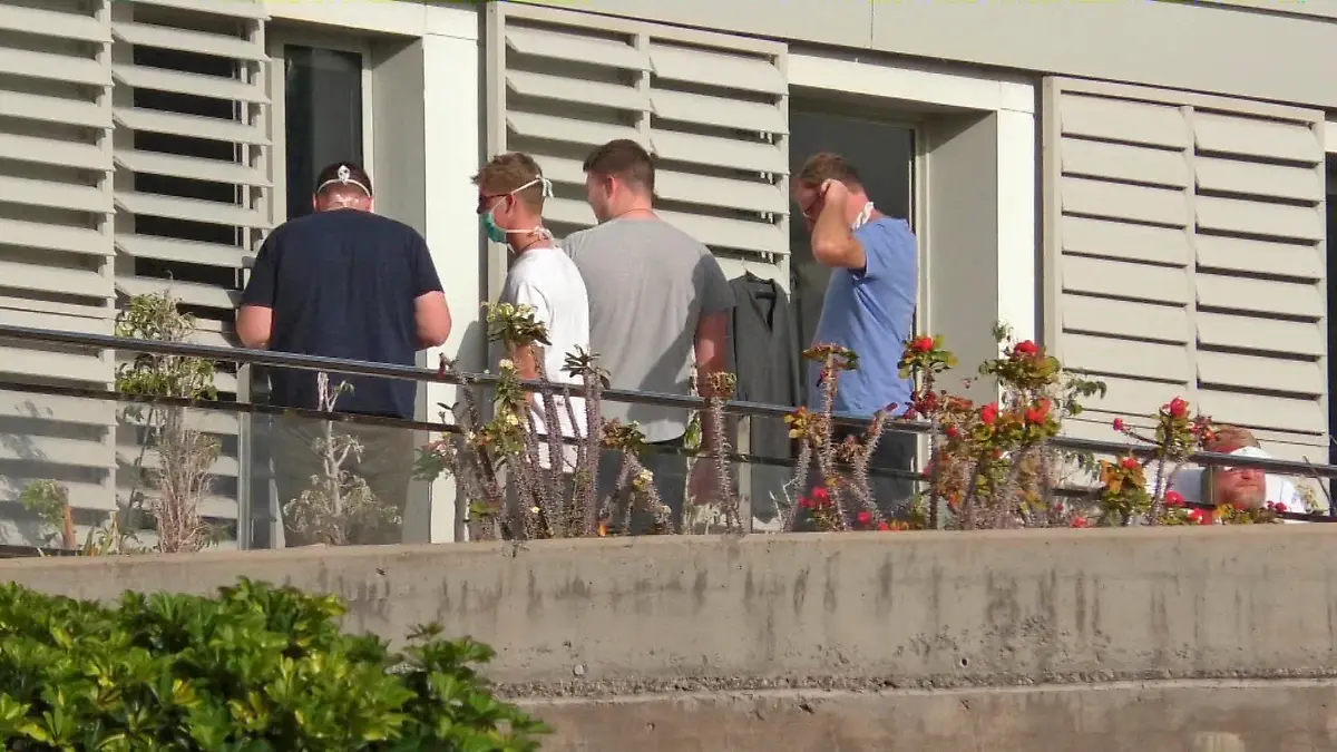 People wearing surgical masks are seen at the balcony of a hospital n the remote Spanish island of La Gomera, where the first case of coronavirus in the country has been confirmed, January 31, 2020. Acfi Press/via REUTERS ATTENTION EDITORS - SPAIN OUT.