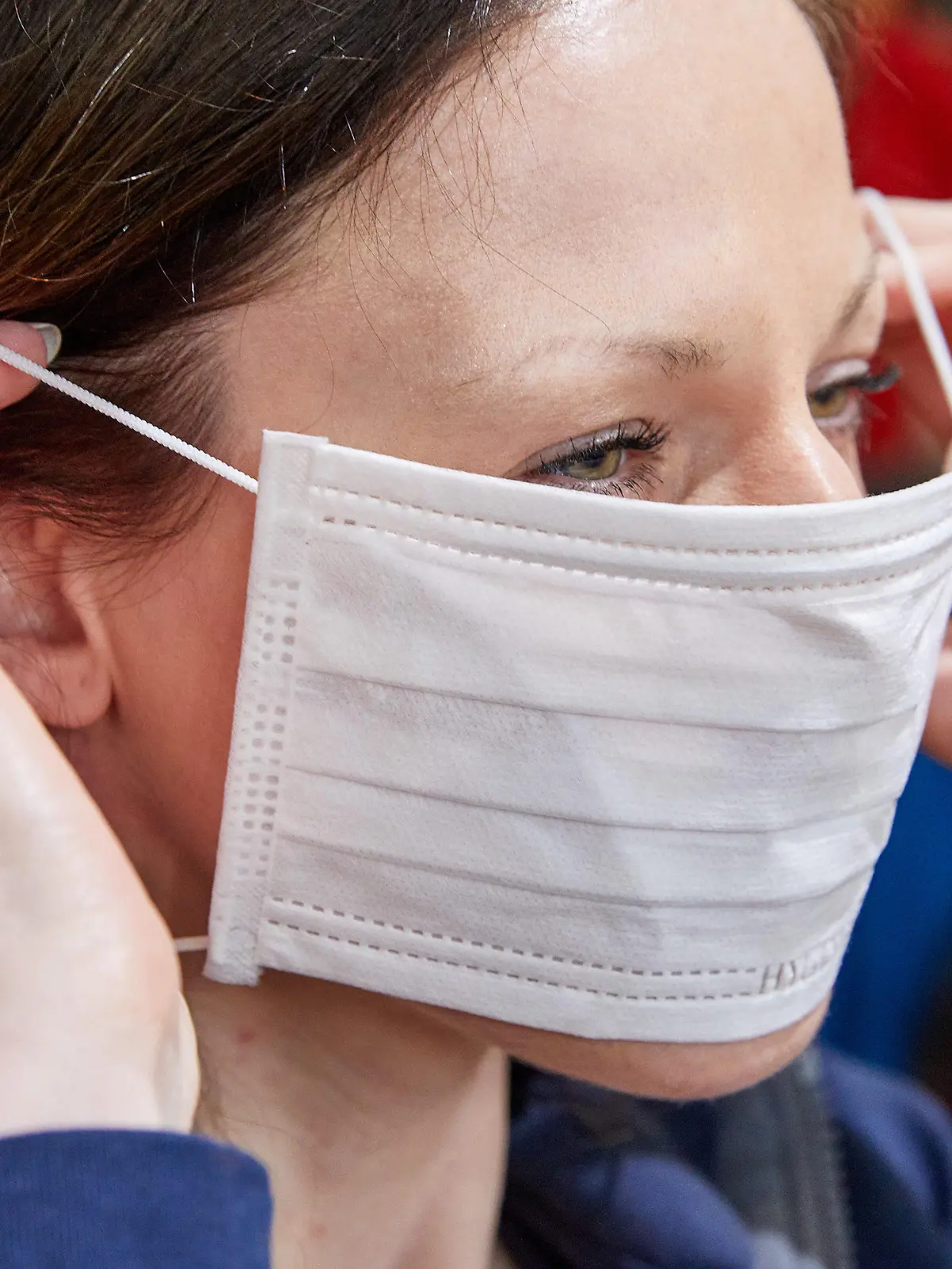 28.01.2020, Hamburg: Illustration - Eine Mitarbeiterin zieht sich in einem Fachgeschäft für Berufskleidung einen Mundschutz an.  Die Sorge vor Ansteckung mit dem neuartigen Coronavirus lässt in deutschen Apotheken die Nachfrage nach Atemmasken steigen. Ein Infektionsexperte hält dagegen Schutzmaßnahmen von Bürgern wie das Tragen von Mundschutz derzeit für unnötig. Foto: Georg Wendt/dpa +++ dpa-Bildfunk +++