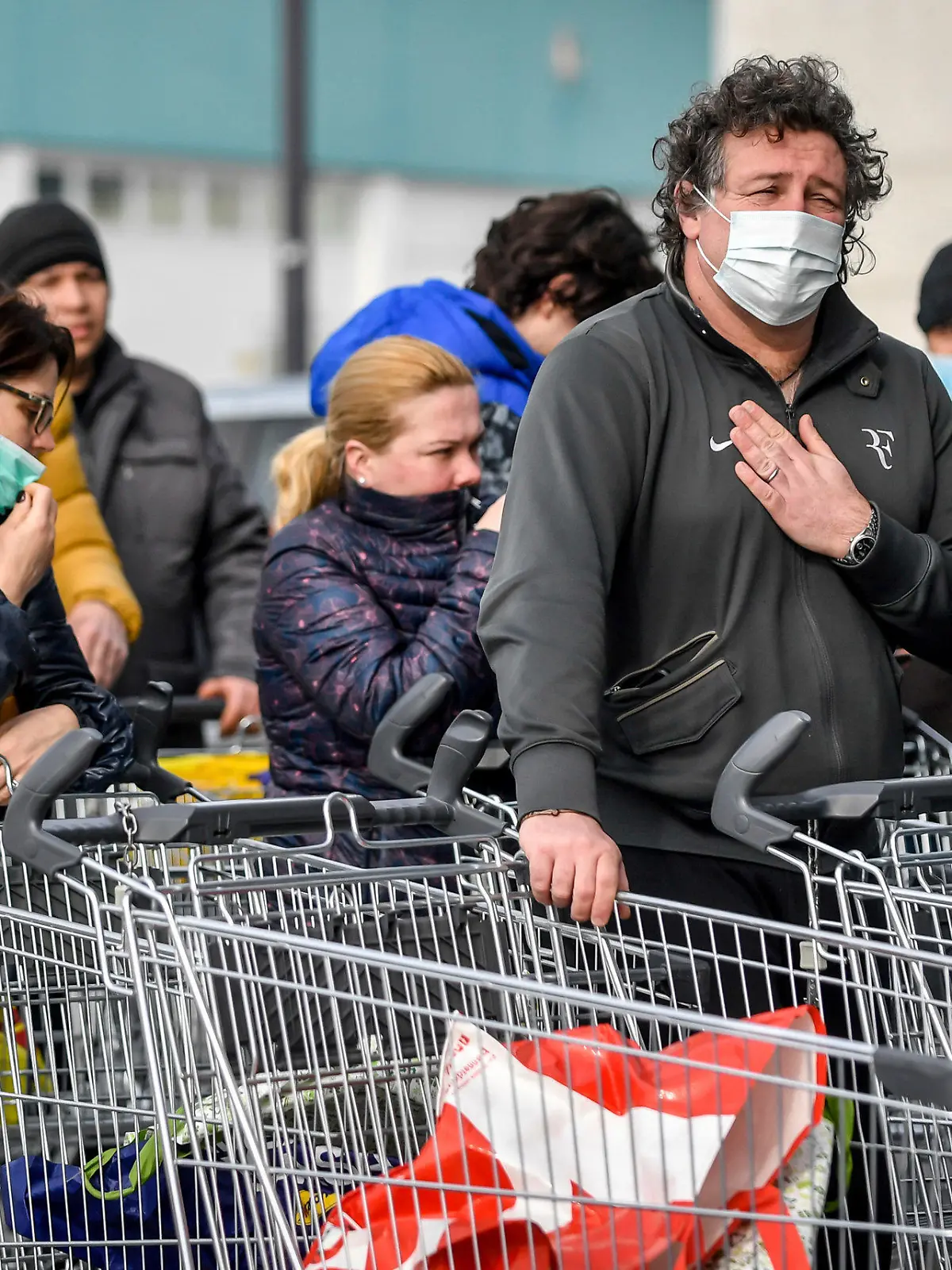 dpatopbilder - 23.02.2020, Italien, Casalpusterlengo: Menschen tragen Atemschutzmasken und stehen vor einem Supermarkt in einer Schlange. Nach dem Tod zweier Menschen sind Teile des öffentlichen Lebens zum Erliegen gekommen. Kein europäisches Land hat mehr Infektionen mit dem Virus Sars-CoV-2 registriert als Italien. Foto: Claudio Furlan/LaPresse/AP/dpa +++ dpa-Bildfunk +++