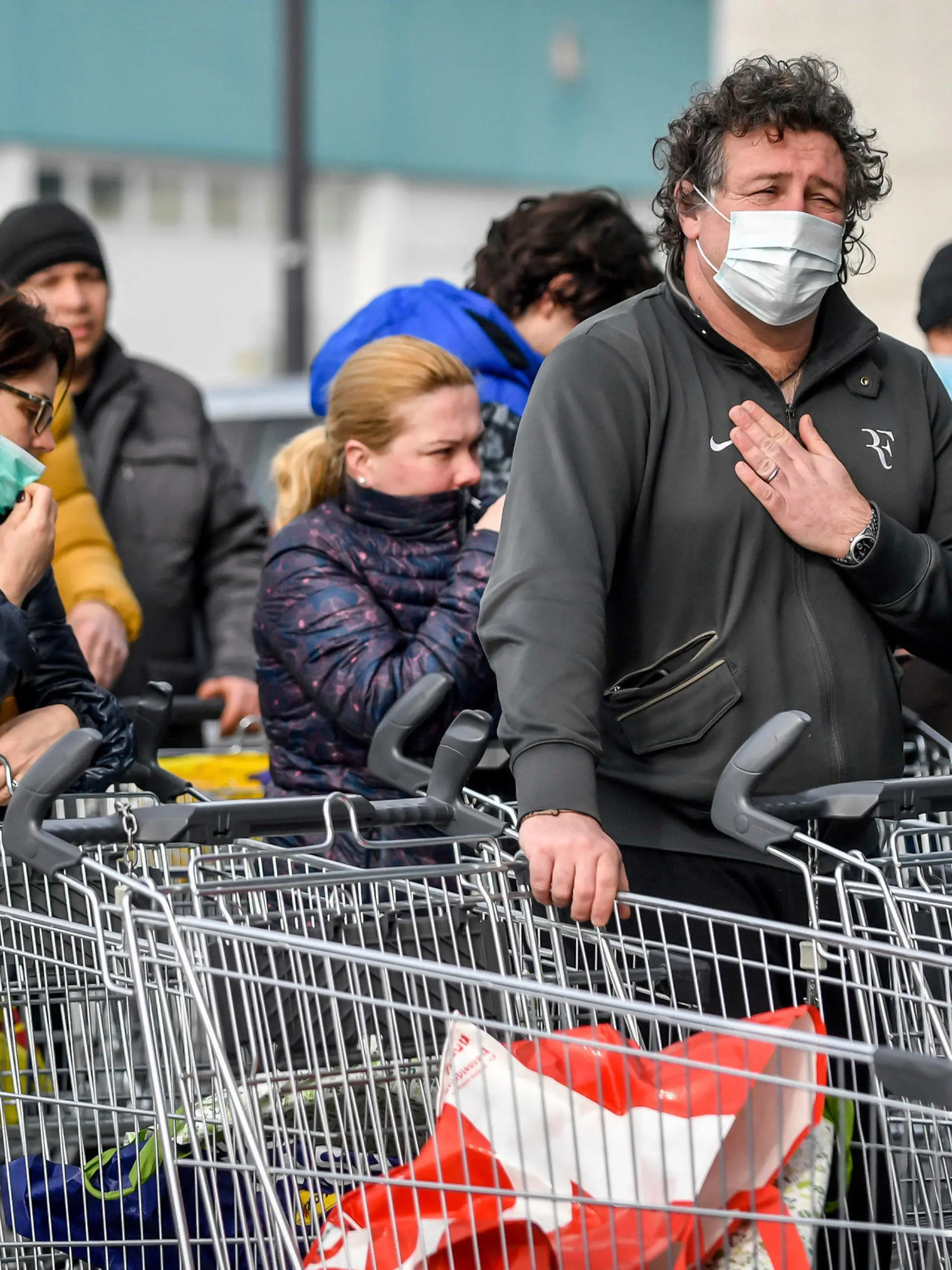 dpatopbilder - 23.02.2020, Italien, Casalpusterlengo: Menschen tragen Atemschutzmasken und stehen vor einem Supermarkt in einer Schlange. Nach dem Tod zweier Menschen sind Teile des öffentlichen Lebens zum Erliegen gekommen. Kein europäisches Land hat mehr Infektionen mit dem Virus Sars-CoV-2 registriert als Italien. Foto: Claudio Furlan/LaPresse/AP/dpa +++ dpa-Bildfunk +++