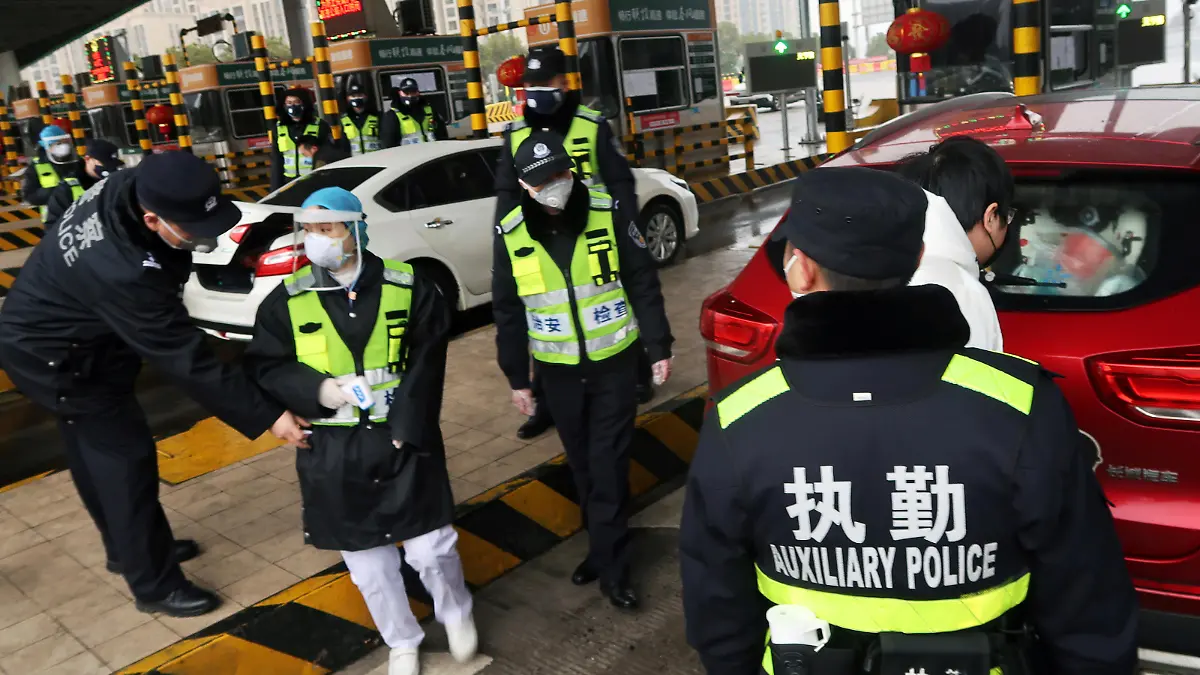 FILE PHOTO: Police officers wearing masks check the boot of a car for smuggled wild animals following the outbreak of a new coronavirus, at an expressway toll station on the eve of the Chinese Lunar New Year celebrations, in Xianning, a city bordering Wuhan to the north, Hubei province, China January 24, 2020. REUTERS/Martin Pollard/File Photo