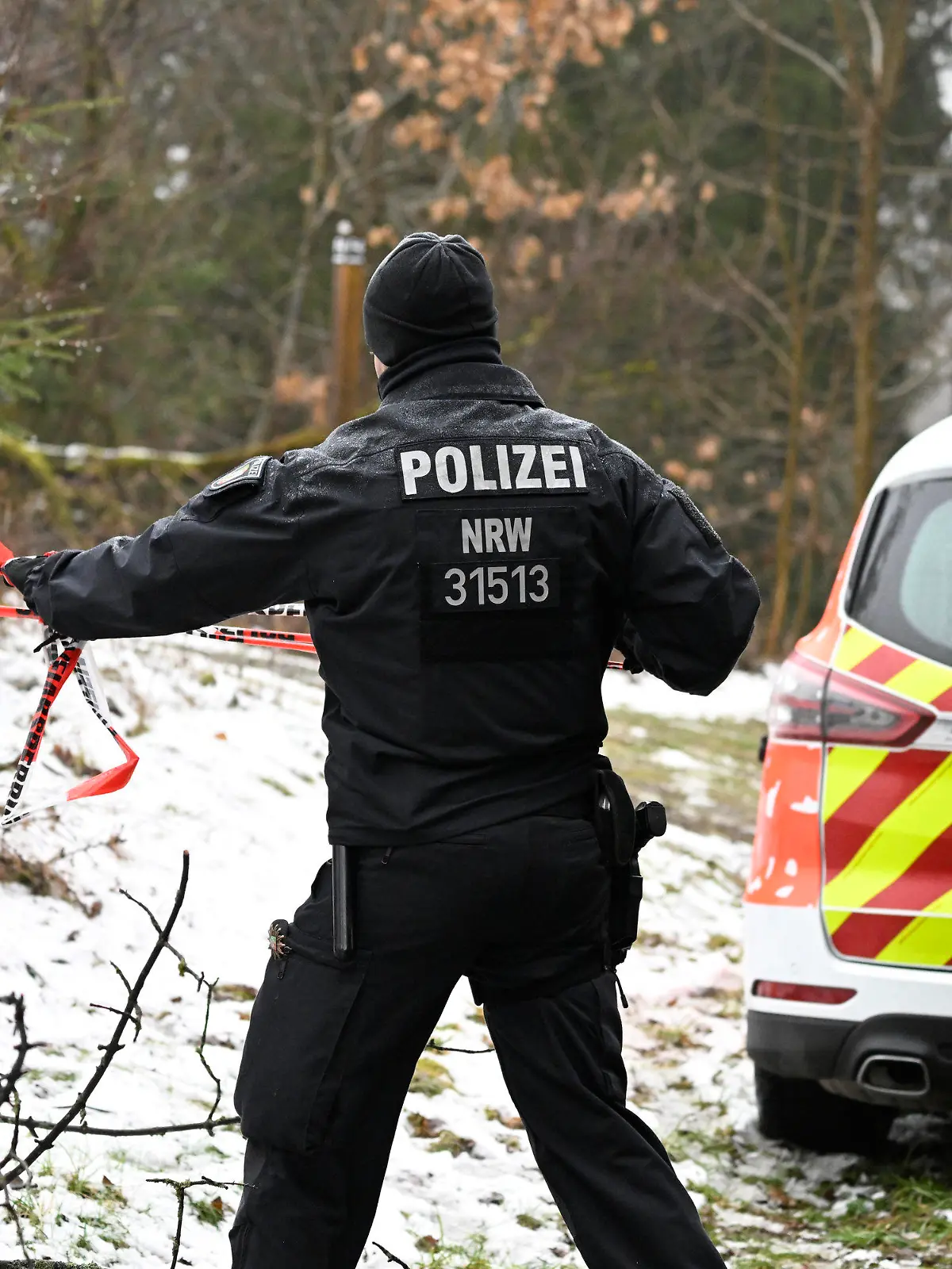 12.03.2023, Nordrhein-Westfalen, Freudenberg: Ein Polizist sperrt die Umgebung nahe des Fundorts einer Leiche weiträumig ab. Die seit Samstagabend vermisste Zwölfjährige aus dem südwestfälischen Freudenberg ist tot. Bei dem am Sonntagmittag gefundenen weiblichen Leichnam handele es sich um das gesuchte Mädchen, teilte die Polizei Koblenz am Abend mit. Foto: Roberto Pfeil/dpa +++ dpa-Bildfunk +++