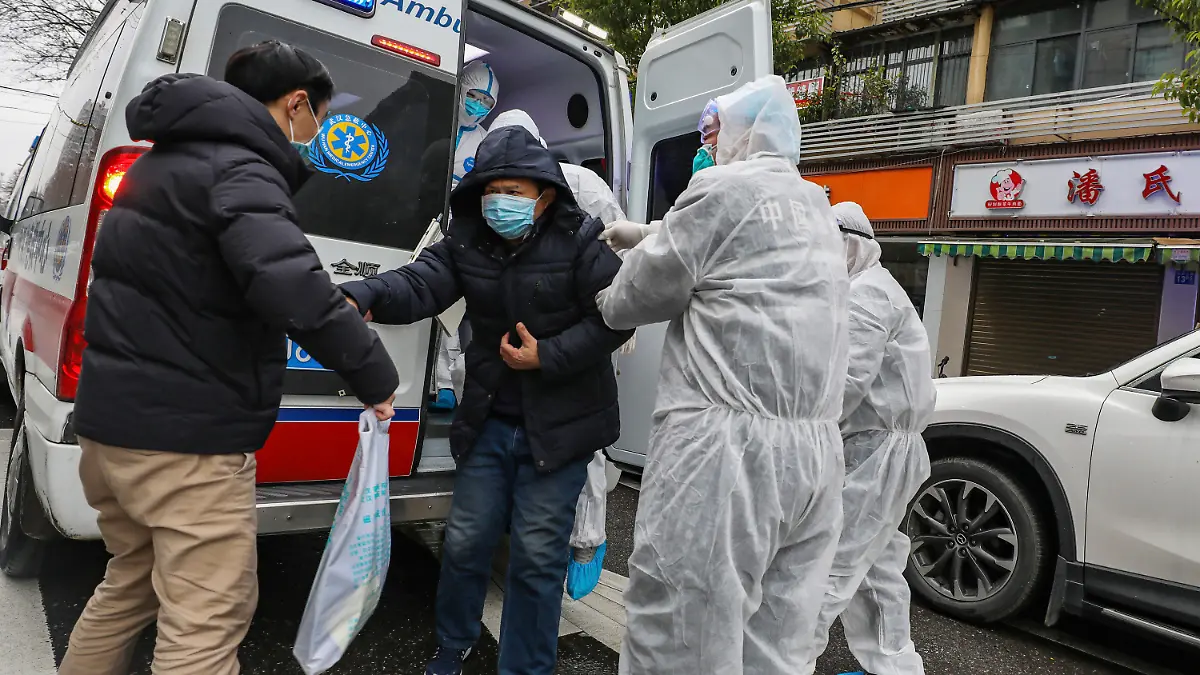 26.01.2020, China, Wuhan: Krankenhausmitarbeiter in Schutzkleidung helfen einem Patienten aus einem Krankenwagen. Angesichts der starken Ausbreitung der neuen Lungenkrankheit hat China seine Maßnahmen am Wochenende deutlich verschärft. Foto: Uncredited/CHINATOPIX/AP/dpa +++ dpa-Bildfunk +++