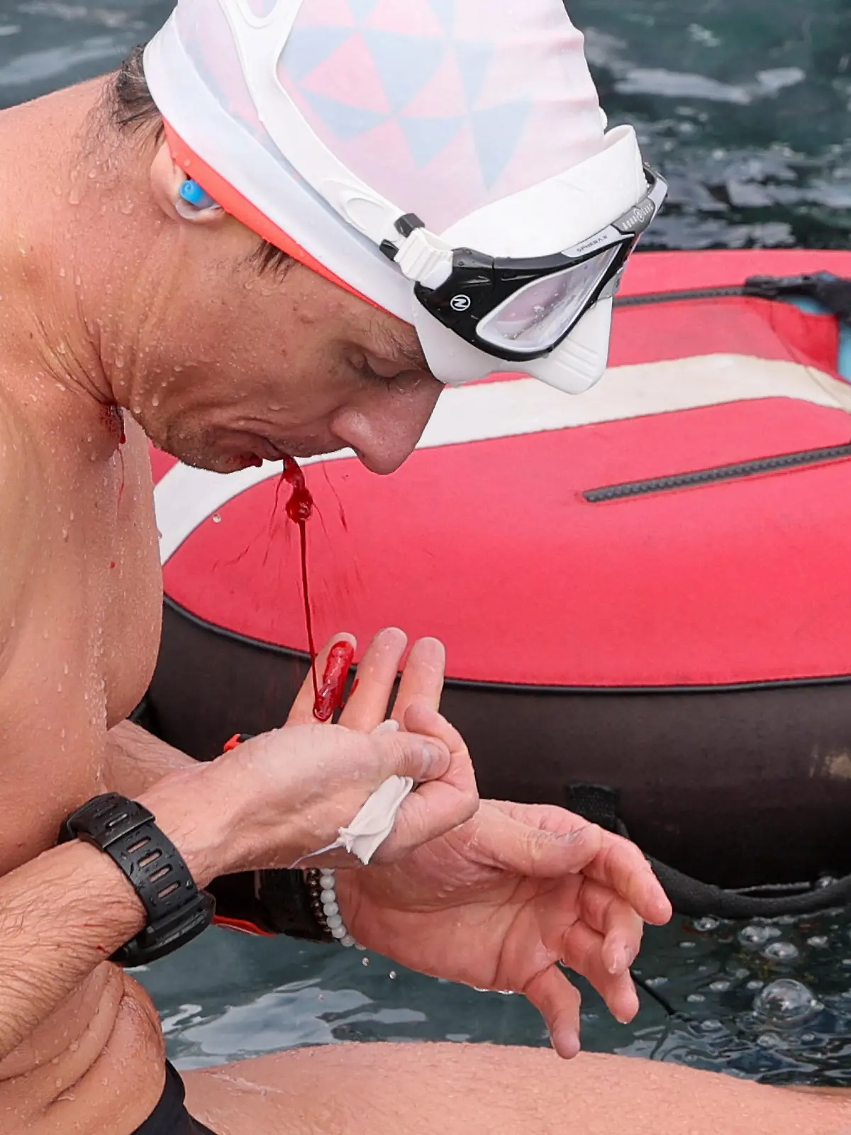 Czech freediver David Vencl spits out blood after his successful attempt to dive 50 metres under the ice of Lake Sils in one breath and wearing only a swimsuit, in Sils near St. Moritz, Switzerland March 14, 2023. REUTERS/Denis Balibouse