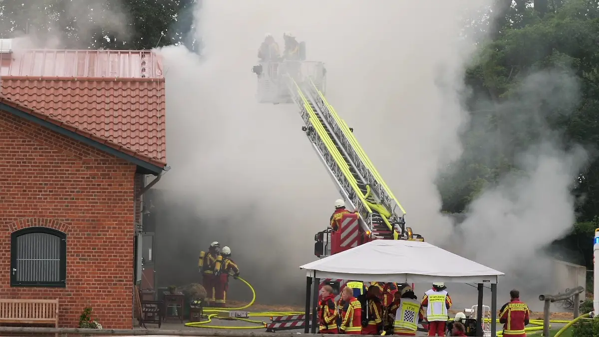 Feuerwehrkräfte löschen eine Scheune die in Flammen steht.