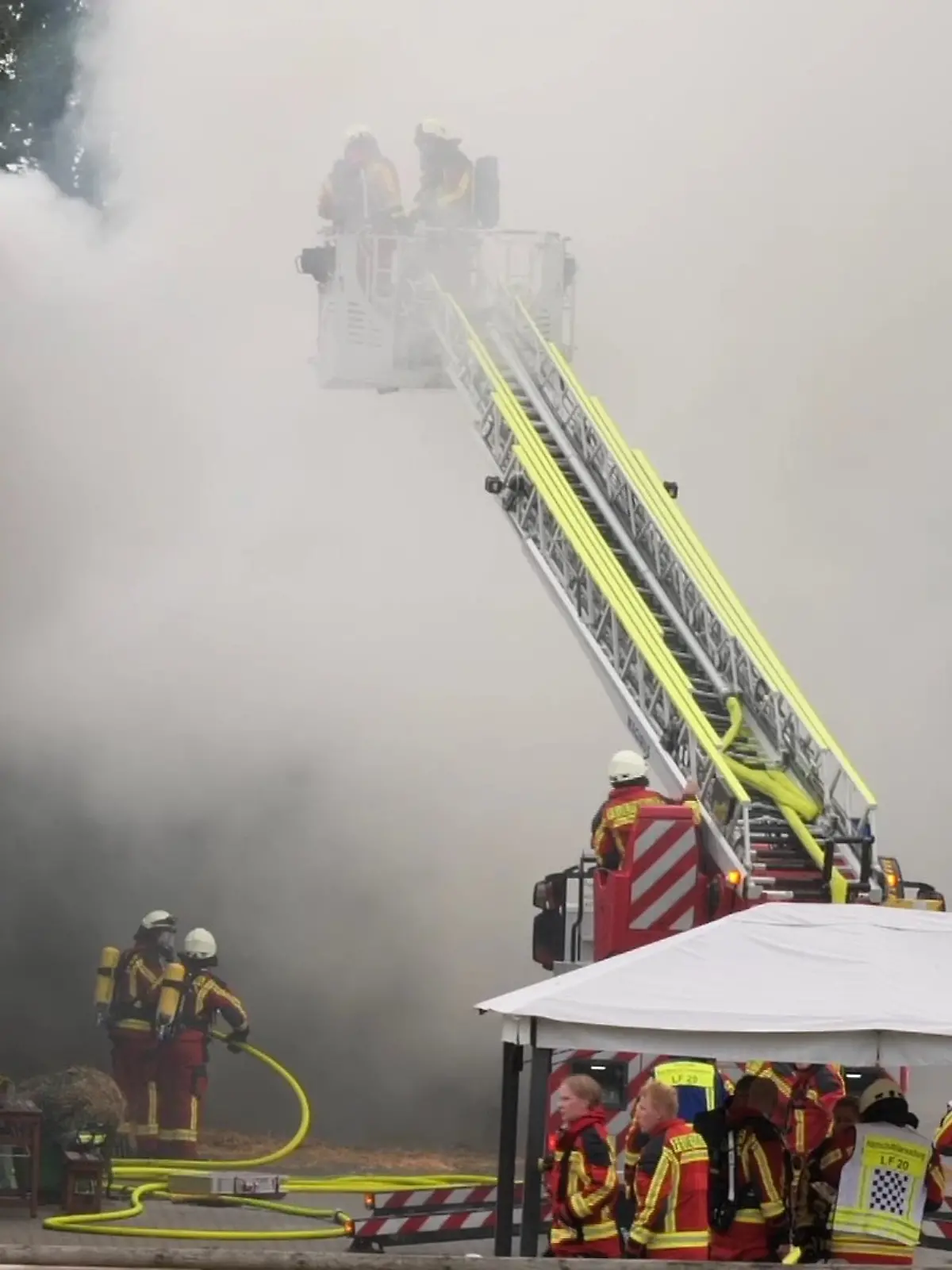 Feuerwehrkräfte löschen eine Scheune die in Flammen steht.