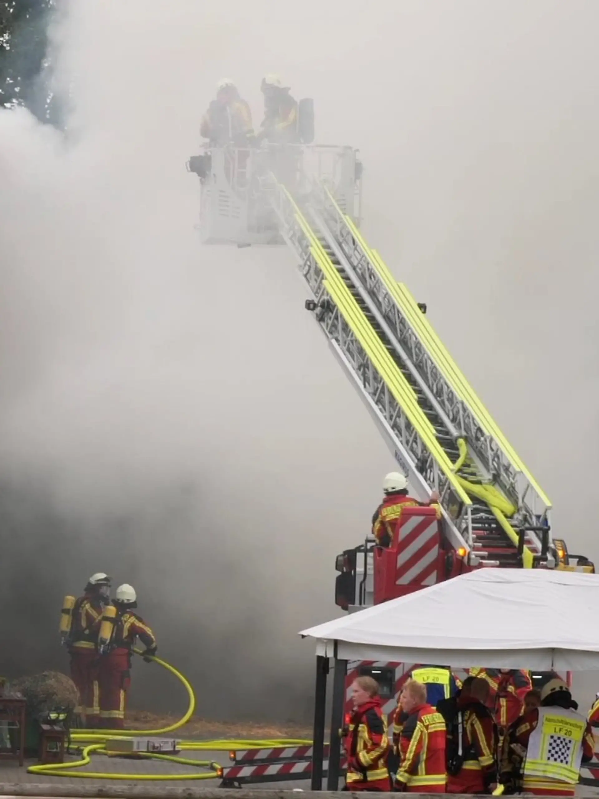 Feuerwehrkräfte löschen eine Scheune die in Flammen steht.