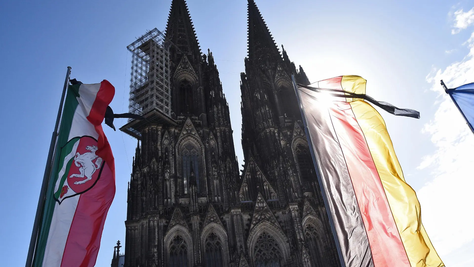 Eine NRW Landesfahne und eine Deutschlandfahne mit Trauerflor wehen m 17.04.2015 in Köln (Nordrhein-Westfalen) vor der Trauerfeier für die Opfer des Germanwings-Absturzes vor dem Dom. Bei dem Flugzeugabsturz in den französischen Alpen waren am 24. März 150 Menschen ums Leben gekommen. Foto: Hennning Kaiser /dpa +++(c) dpa - Bildfunk+++