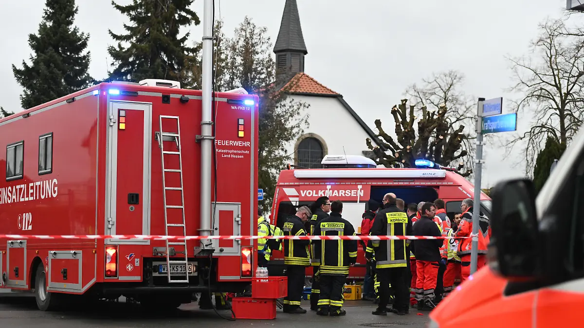 24.02.2020, Hessen, Volkmarsen: Feuerwehrleute und Notfallsanitäter stehen hinter einem Absperrband an der Stelle, an der ein Auto in einen Rosenmontagsumzug gefahren ist. Dabei gab es mehrere Verletzte. Die Polizei hat nach eigenen Angaben noch keine Erkenntnisse über die Hintergründe. Foto: Uwe Zucchi/dpa +++ dpa-Bildfunk +++