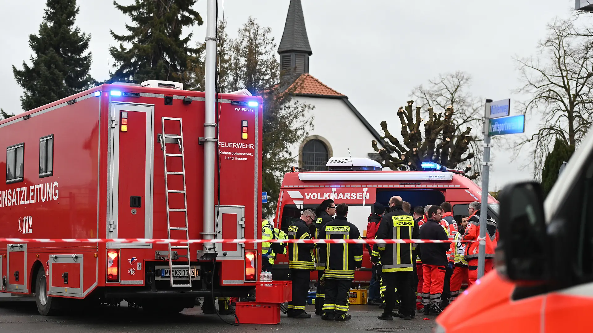 24.02.2020, Hessen, Volkmarsen: Feuerwehrleute und Notfallsanitäter stehen hinter einem Absperrband an der Stelle, an der ein Auto in einen Rosenmontagsumzug gefahren ist. Dabei gab es mehrere Verletzte. Die Polizei hat nach eigenen Angaben noch keine Erkenntnisse über die Hintergründe. Foto: Uwe Zucchi/dpa +++ dpa-Bildfunk +++