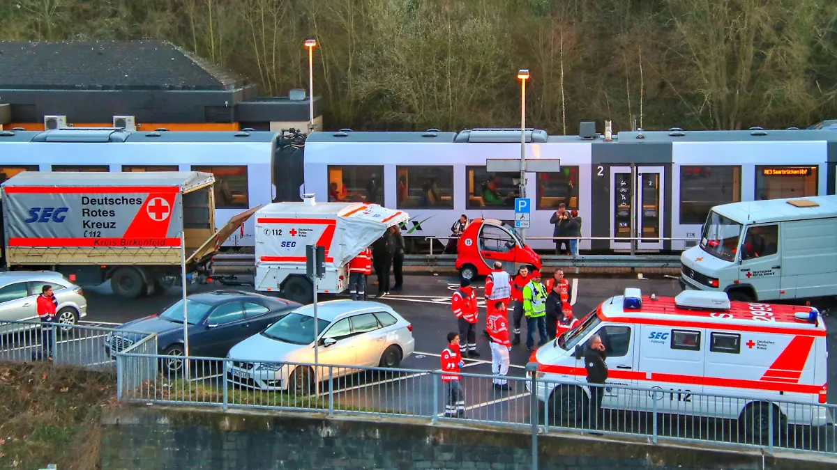 26.02.2020, Rheinland-Pfalz, Idar-Oberstein: Rettungssanitäter stehen am Bahnhof. Die Bundespolizei in Idar-Oberstein hatte hier einen Regionalzug mit etwa 70 Fahrgästen wegen Coronavirus-Verdachts gestoppt. Es habe einen Hinweis gegeben, dass ein Reisender möglicherweise mit dem Virus infiziert sei, sagte eine Sprecherin des rheinland-pfälzischen Gesundheitsministeriums. Foto: Sebastian Schmitt/dpa - ACHTUNG: Privatpersonen wurden Gründen gepixelt +++ dpa-Bildfunk +++