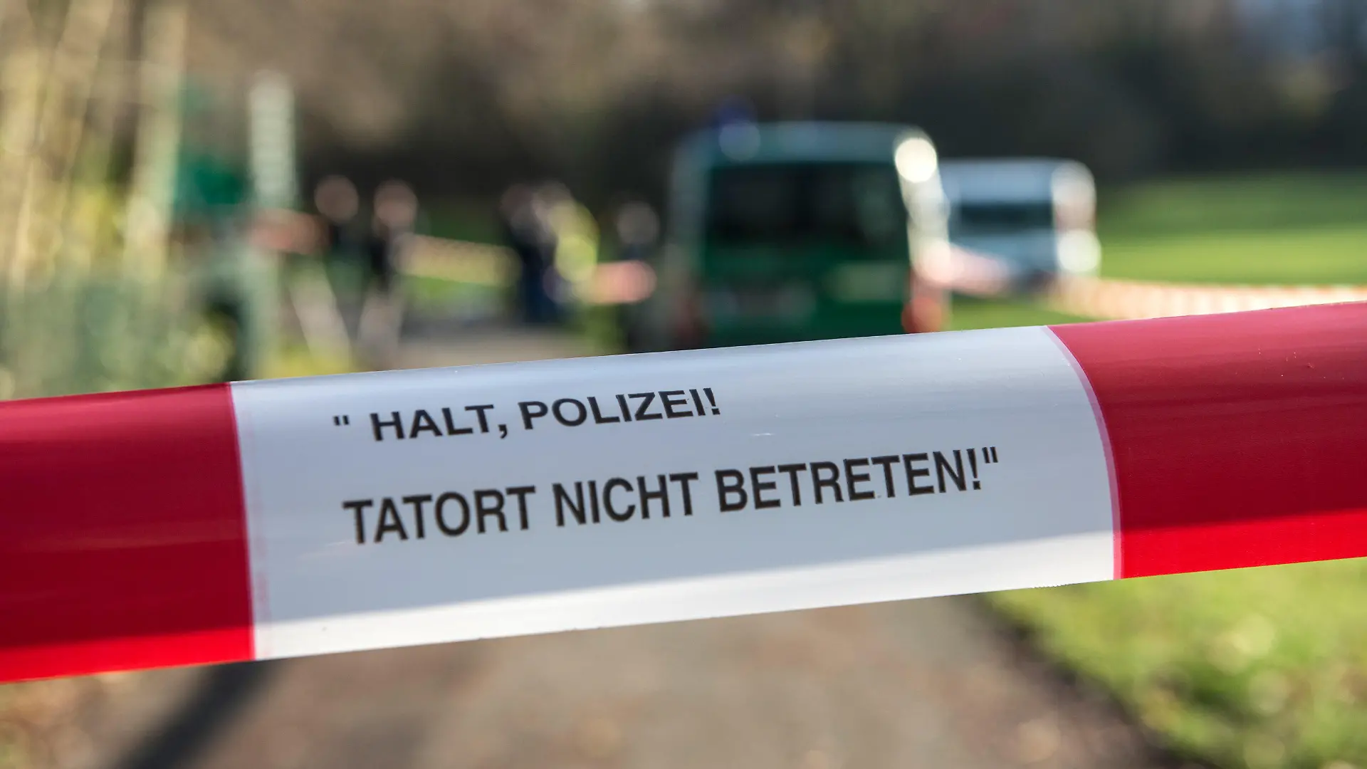 Absperrband mit der Aufschrift «Halt, Polizei! Tatort nicht betreten» hängt über einen Weg gespannt am 29.11.2017 in Berlin am Britzer Fennpfuhl-Teich. Dort suchten Polizeitaucher nach Stolpersteinen. In Berlin-Neukölln waren im November 16 «Stolpersteine» an 13 Tatorten aus dem Boden gerissen worden. Der polizeiliche Staatsschutz ermittelt. Die kleinen glänzenden Metallsteine erinnern an Opfer des Nationalsozialismus, meist an in Konzentrationslager deportierte und ermordete Juden. Sie sind an vielen Orten in den Bürgersteigbelag eingesetzt, direkt vor Häusern, in denen die Menschen gewohnt haben. Foto: Paul Zinken/dpa +++(c) dpa - Bildfunk+++