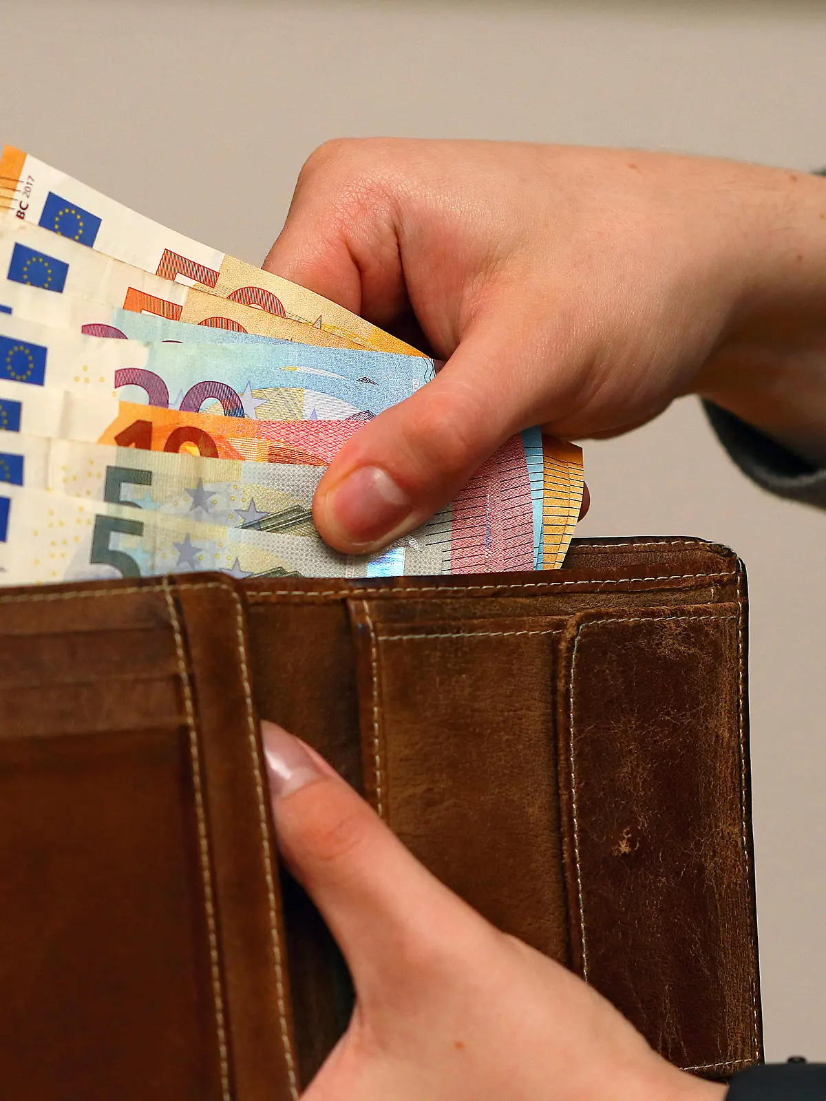 Symbolbild: Eine Frau zählt ihre Geldscheine ihrem Portemonnaie. In Zeiten von steigenden Energiekosten müssen viele Bürger den sparen.
