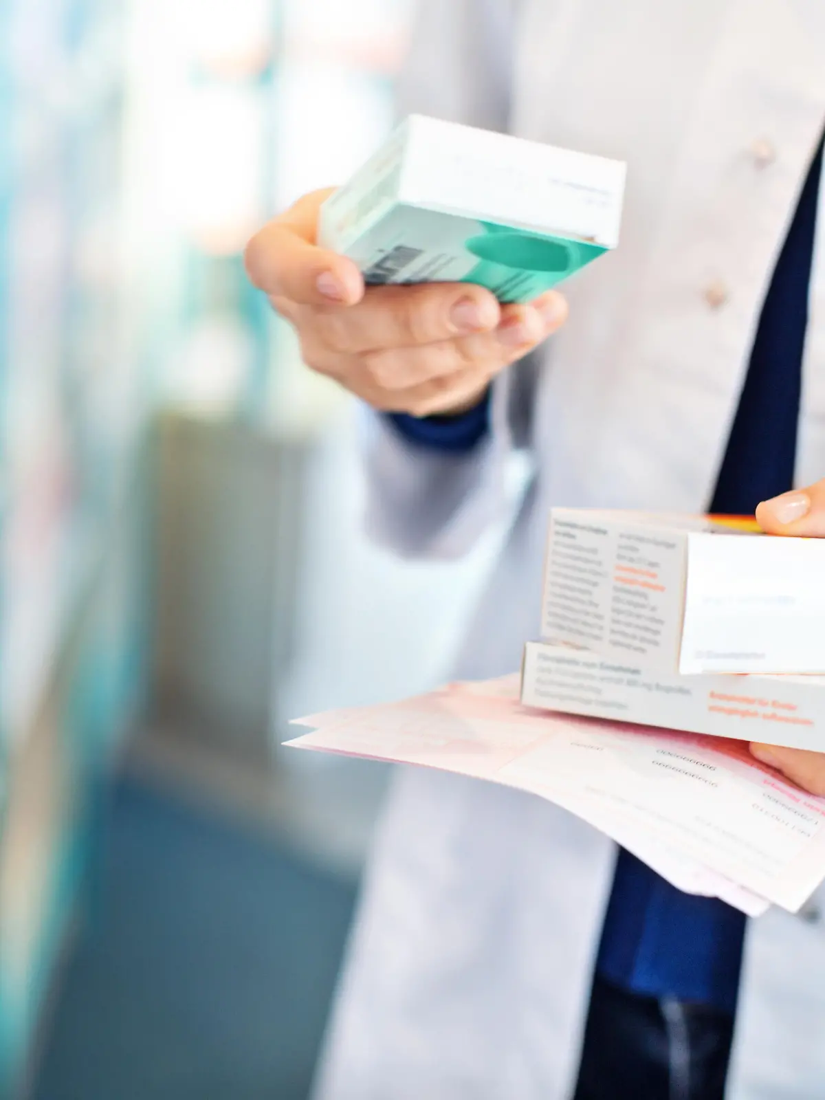 Closeup of pharmacist's hands taking medicines from shelf at the pharmacy