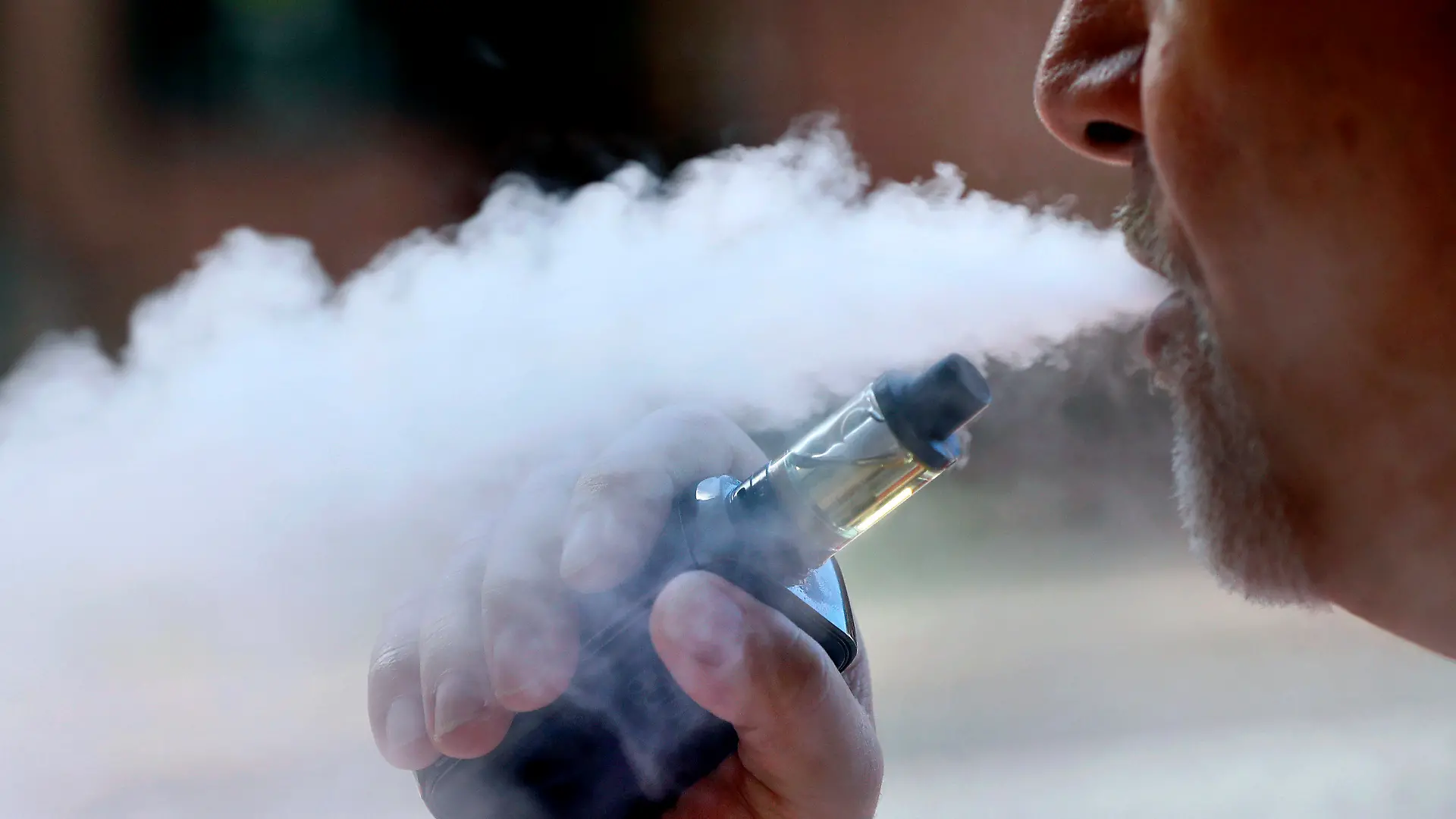 ARCHIV - 28.08.2019, USA, Portland: Ein Mann raucht eine E-Zigarette in Portland, Maine raucht. Die US-Gesundheitsbehörde CDC untersucht, ob der Gebrauch von E-Zigaretten zu schweren Lungenerkrankungen geführt hat. Foto: Robert F. Bukaty/AP/dpa +++ dpa-Bildfunk +++