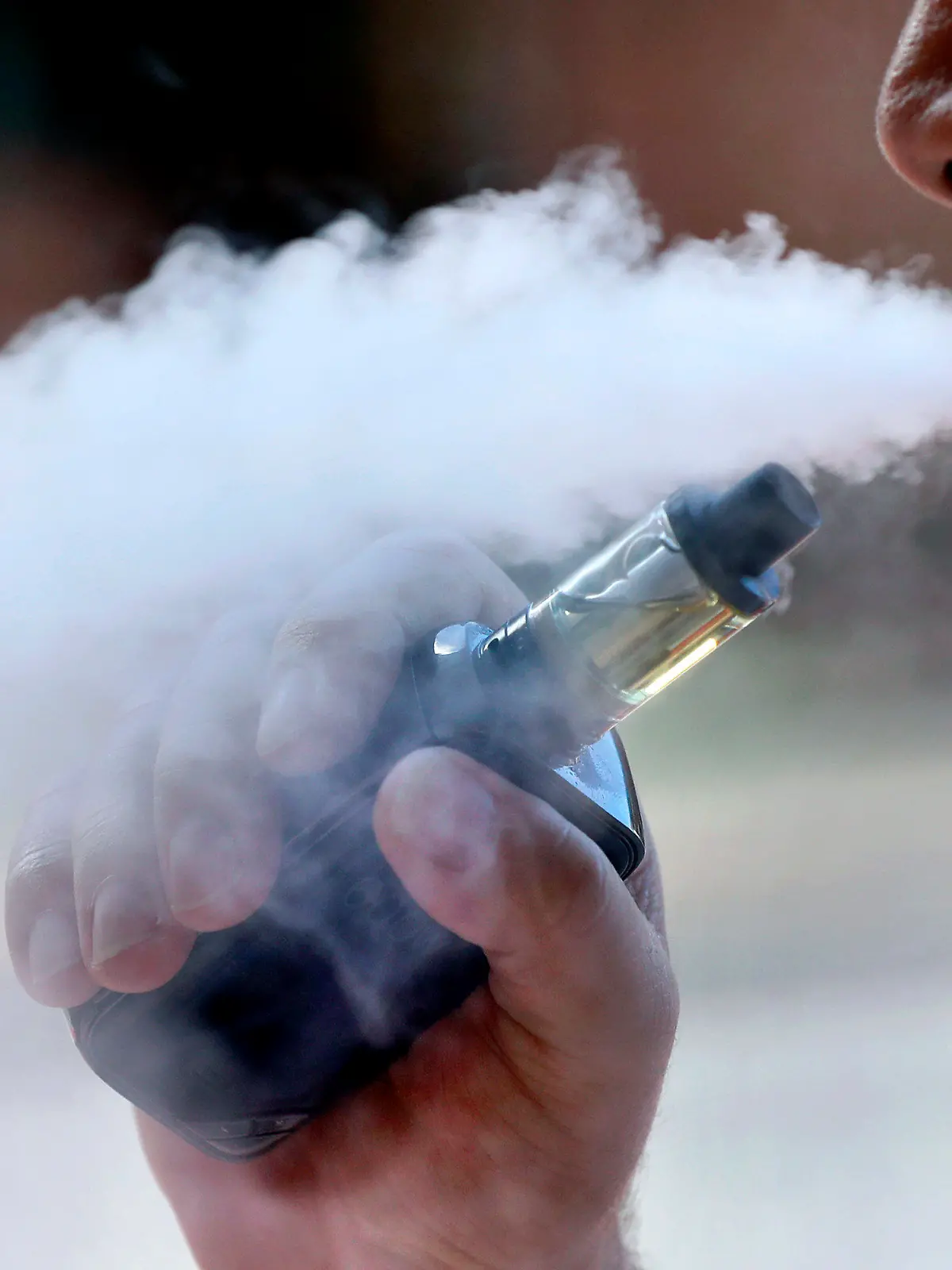 ARCHIV - 28.08.2019, USA, Portland: Ein Mann raucht eine E-Zigarette in Portland, Maine raucht. Die US-Gesundheitsbehörde CDC untersucht, ob der Gebrauch von E-Zigaretten zu schweren Lungenerkrankungen geführt hat. Foto: Robert F. Bukaty/AP/dpa +++ dpa-Bildfunk +++