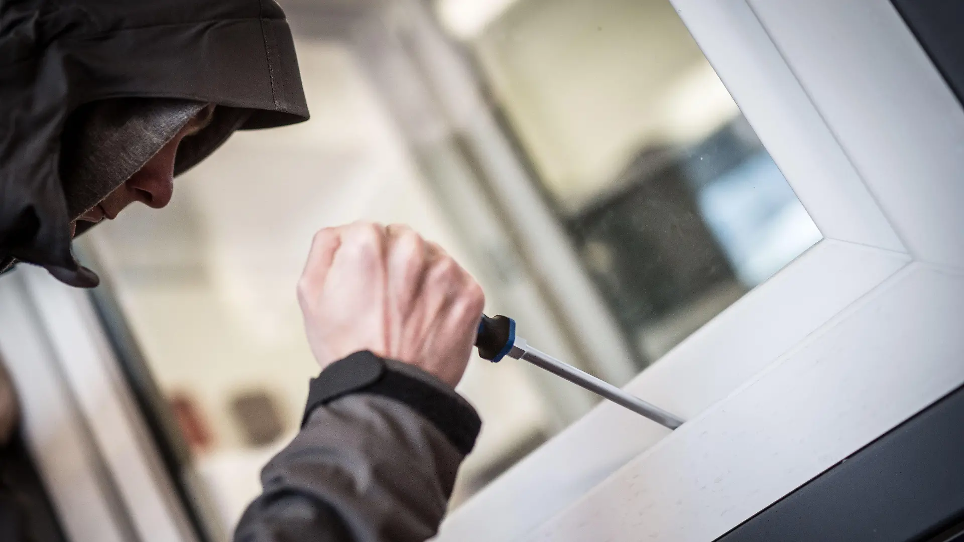 ARCHIV - ILLUSTRATION - Ein Mann demonstriert am 10.04.2015 in der polizeilichen Beratungsstelle in Frankfurt am Main (Hessen), wie einfach es für einen Einbrecher wäre, mit Hilfe eines stabilen Schraubenziehers ein geschlossenes Fenster von außen zu öffnen. (zu dpa «Innenministerium: Zahl der Einbrüche leicht rückläufig» vom 29.10.2017) Foto: Frank Rumpenhorst/dpa +++(c) dpa - Bildfunk+++